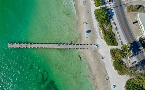An aerial view of a pier in the middle of a body of water.