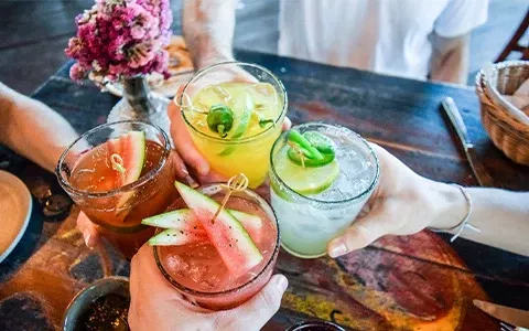 A group of people are toasting with drinks at a table.