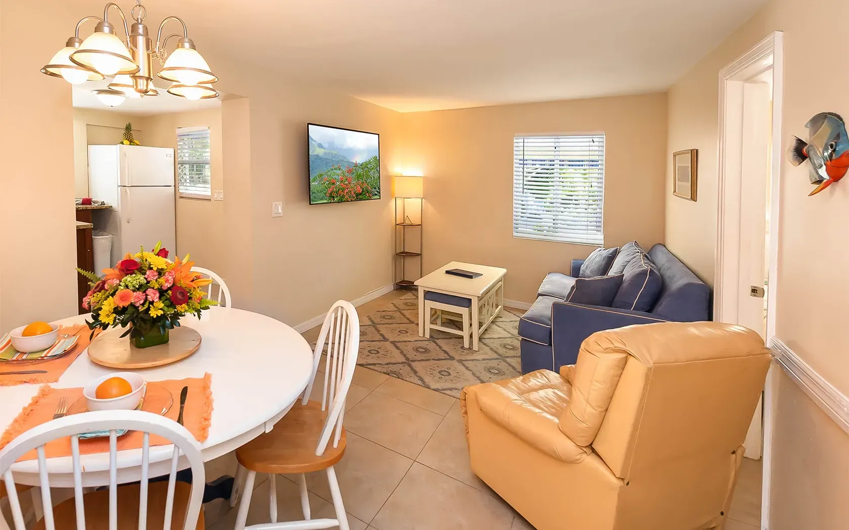 A living room with a couch , chair , table and television.