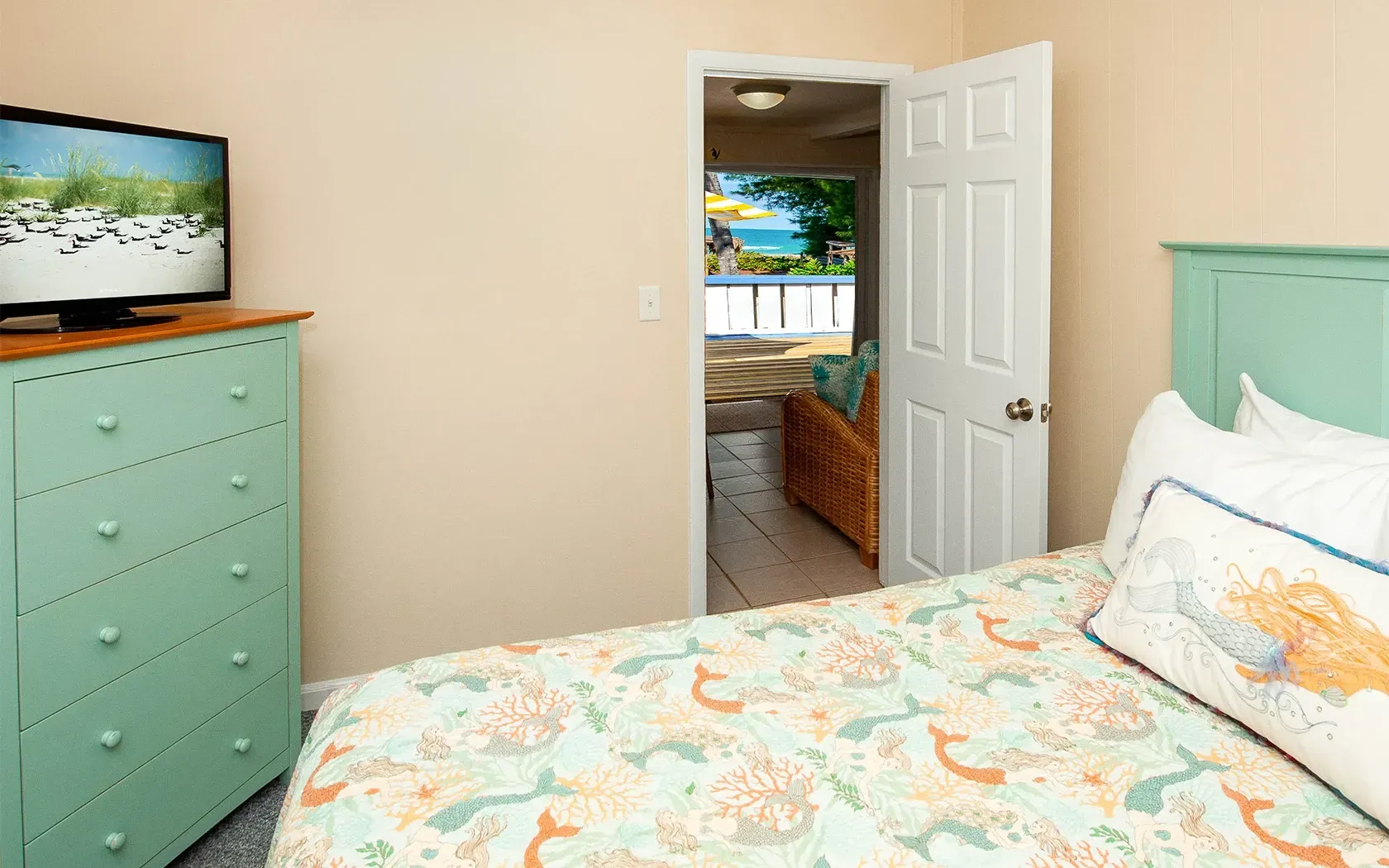 A bedroom with a bed , dresser , and television.