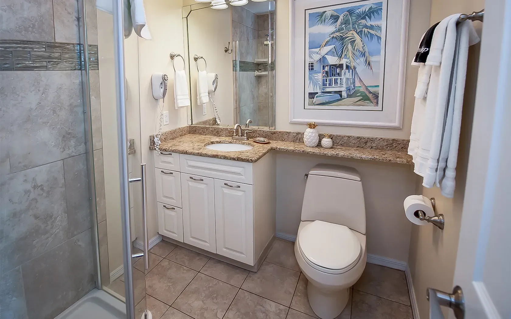 A bathroom with a toilet , sink and shower.