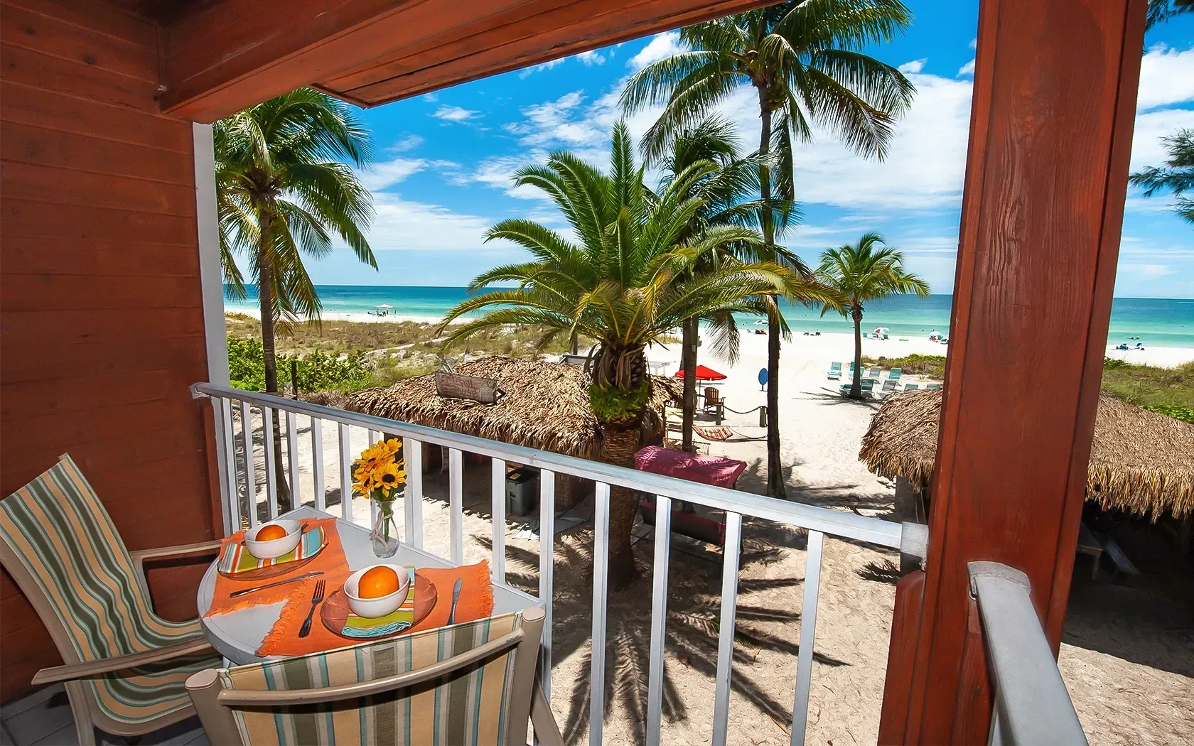 A balcony with a table and chairs overlooking the ocean