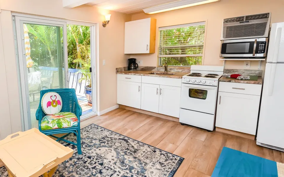 kitchen with white cabinets, appliances, and a sliding glass door to a patio.