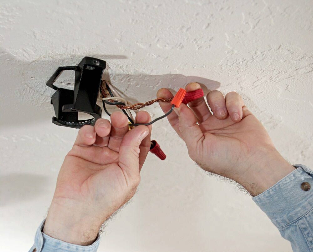 A Person is Holding a Bunch of Wires in Their Hands — Big Bang Electrical And Air In Trinity Park, QLD