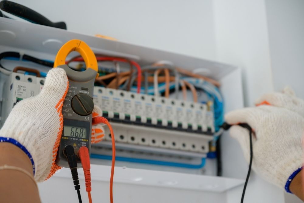 Hands in Work Gloves Use a Clamp Meter — Big Bang Electrical And Air In Trinity Park, QLD