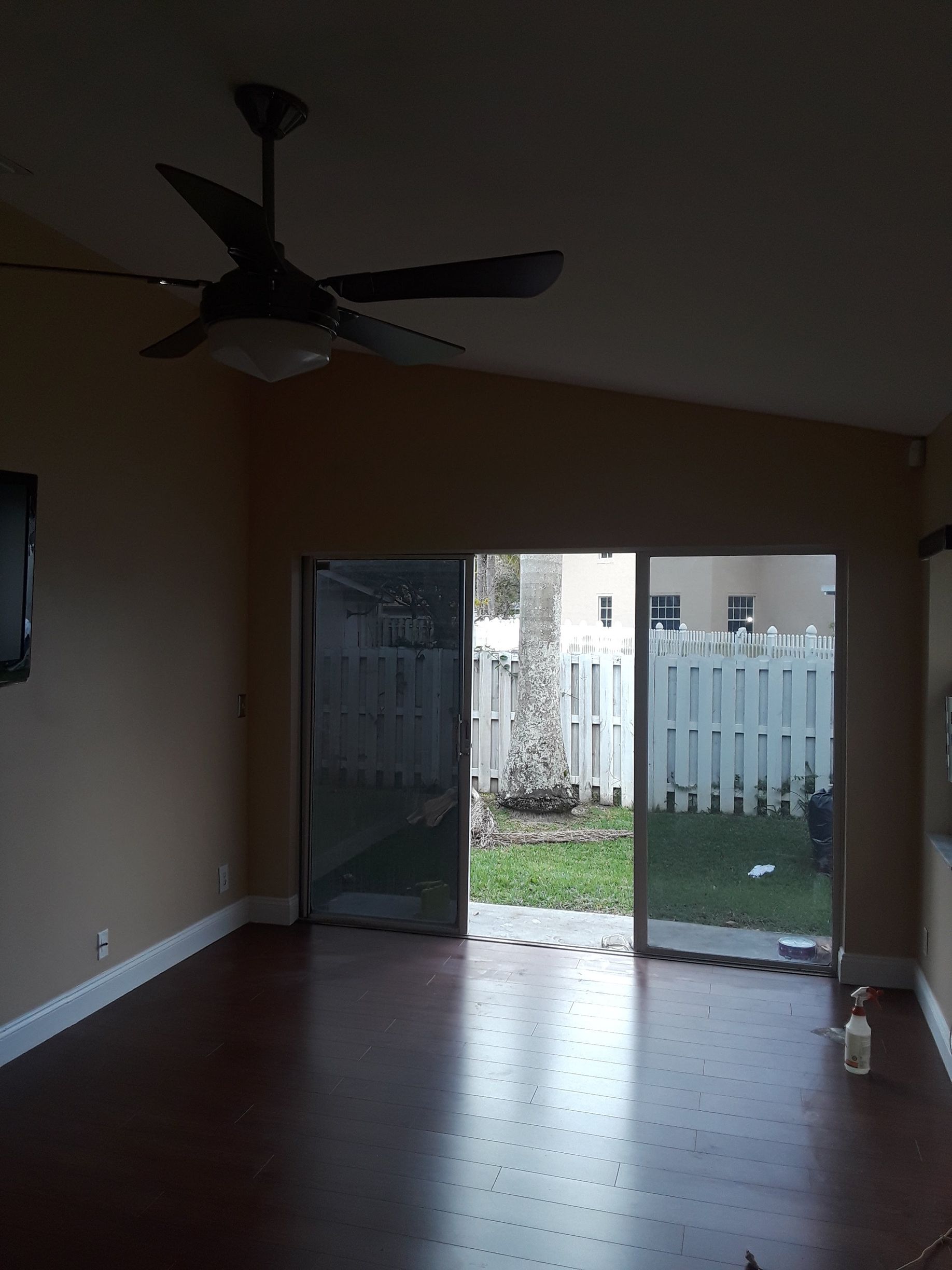 A living room with a ceiling fan and a sliding glass door