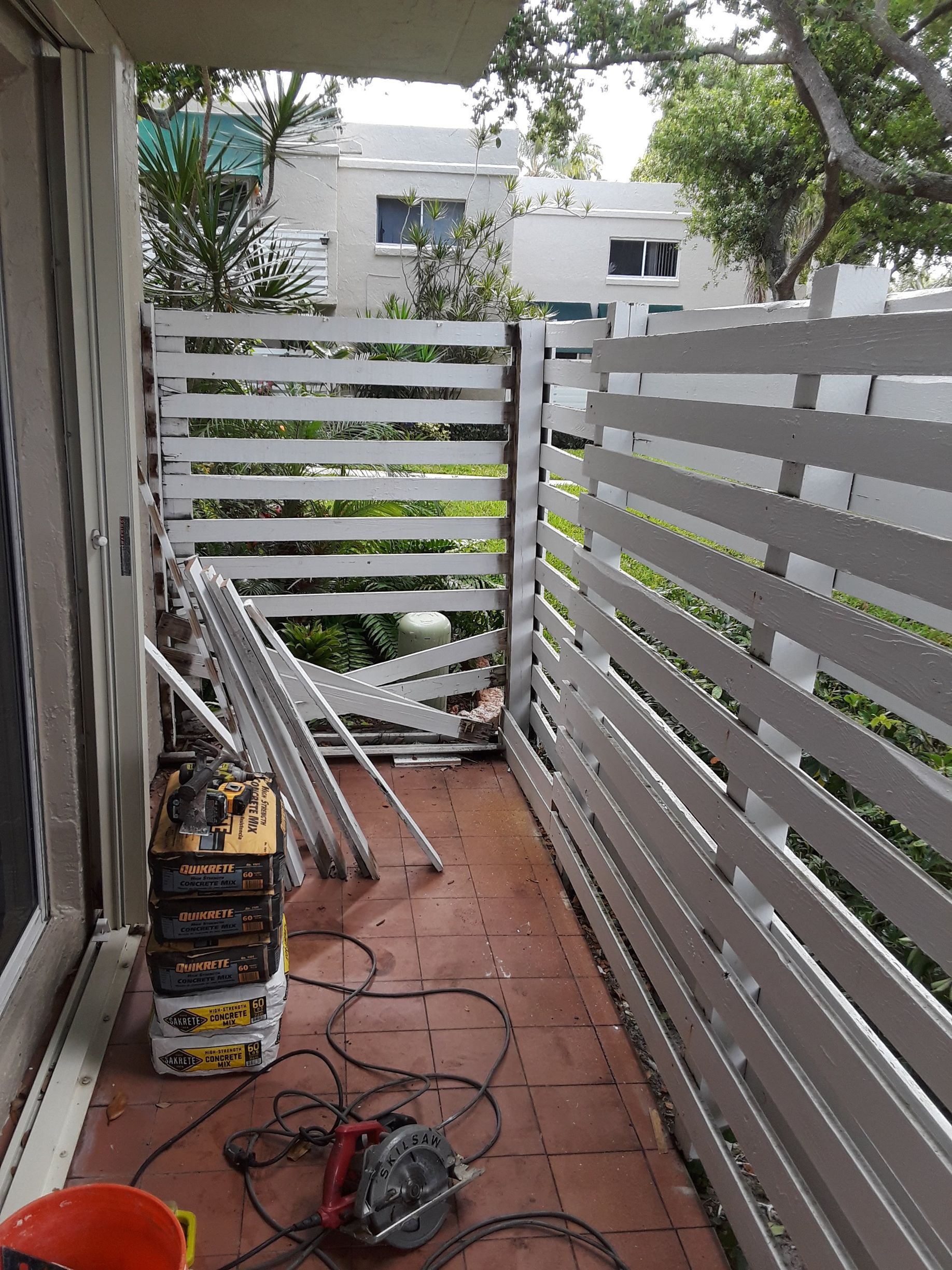 A white fence is being built on a balcony.