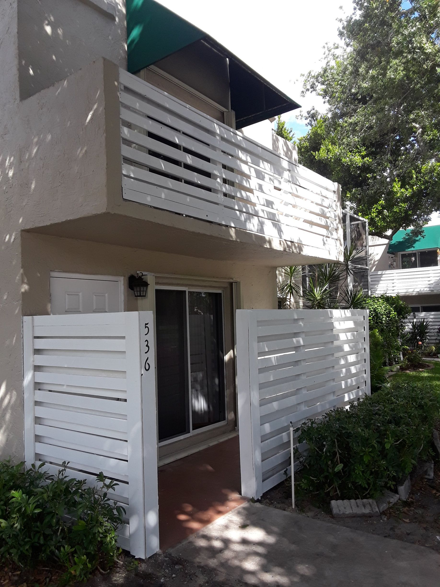 A house with a balcony and a white fence
