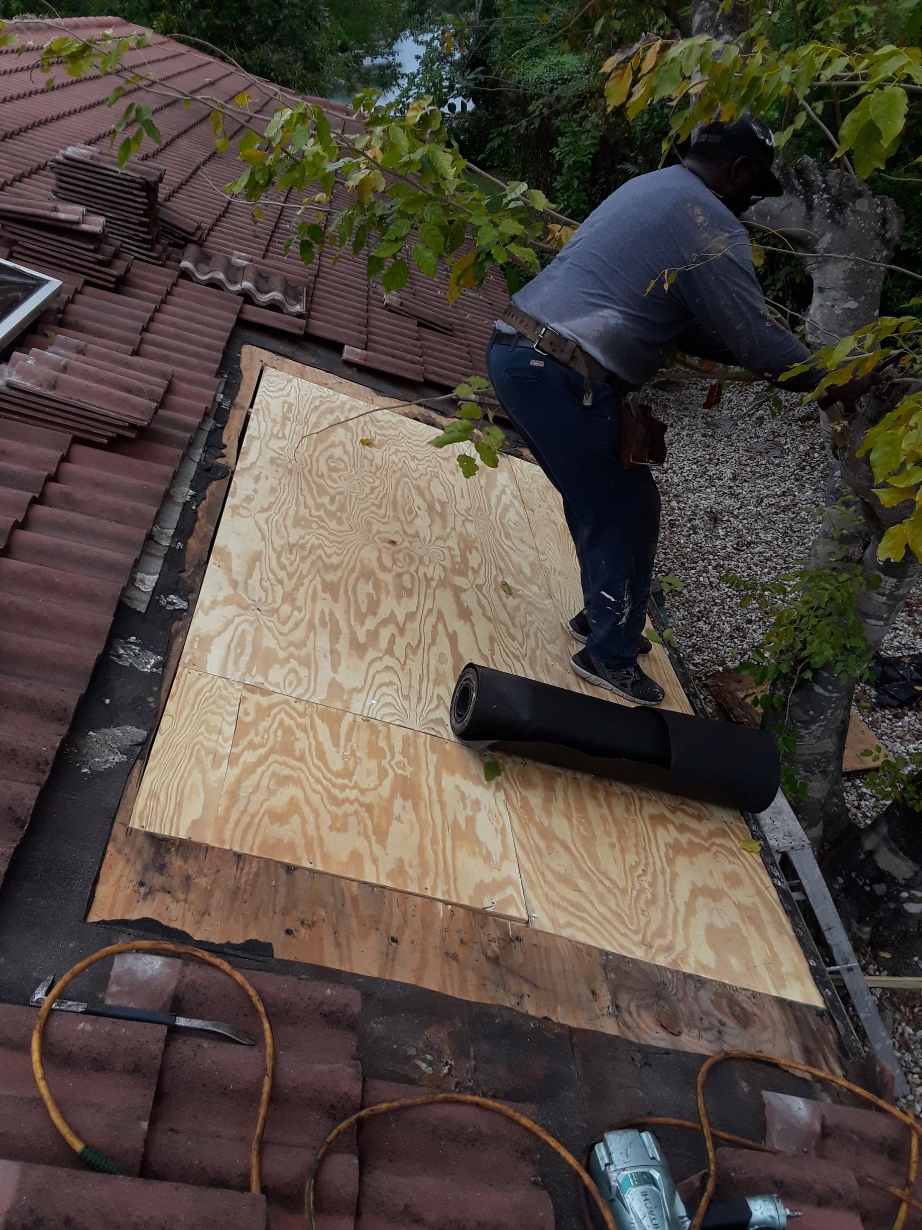 A man is working on the roof of a house.