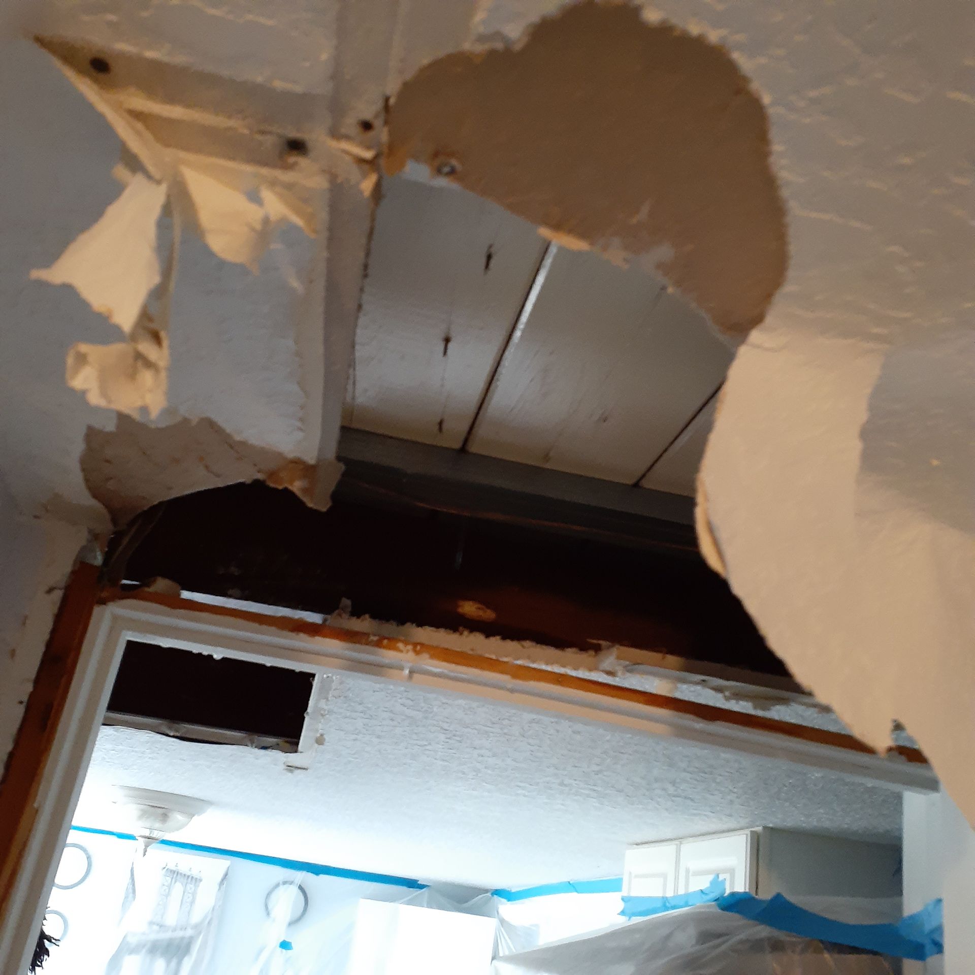 A hole in the ceiling of a room with a door.