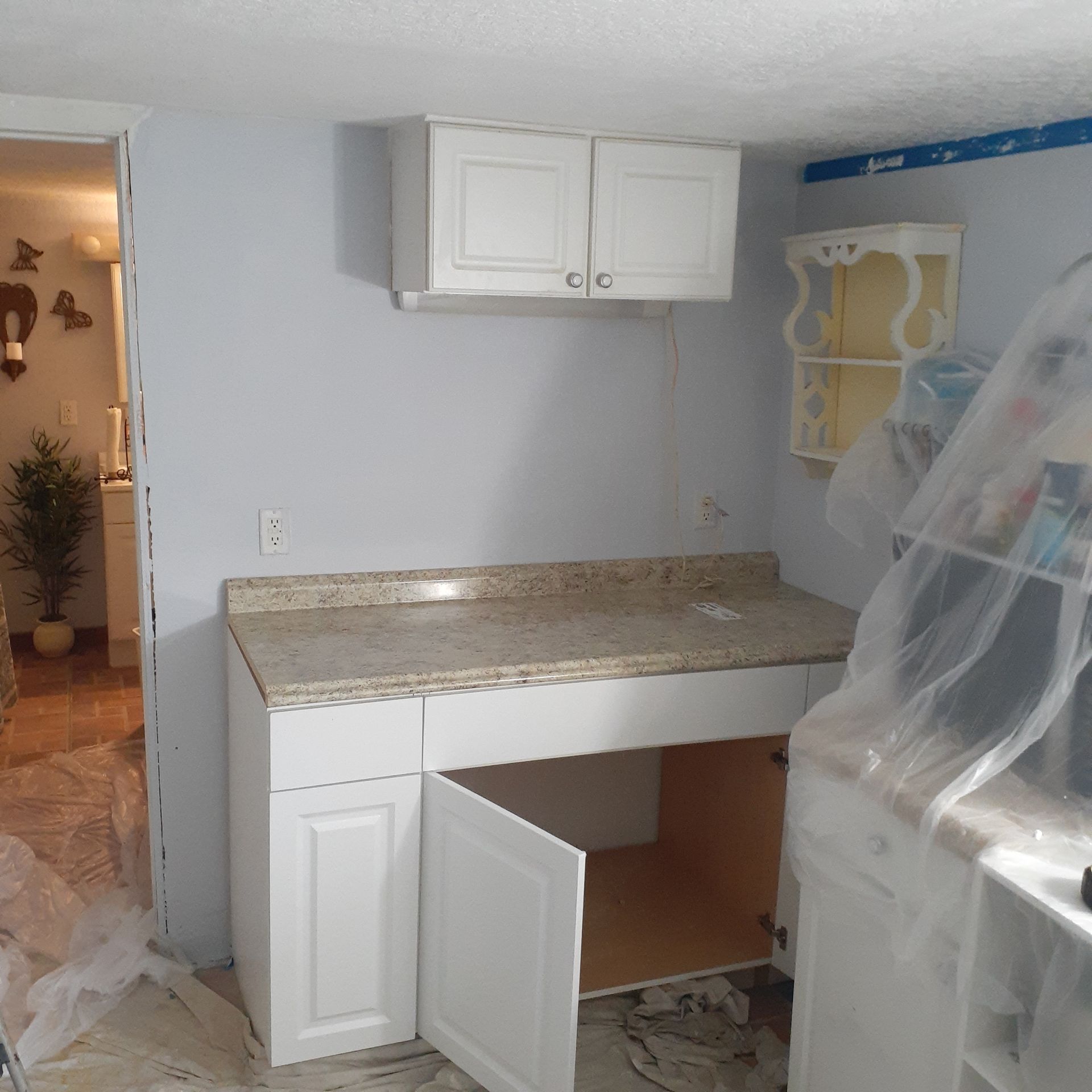 A kitchen with white cabinets and granite counter tops