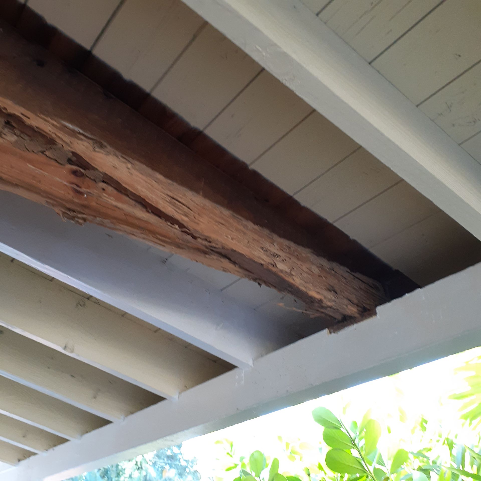 A wooden beam is hanging from the ceiling of a building
