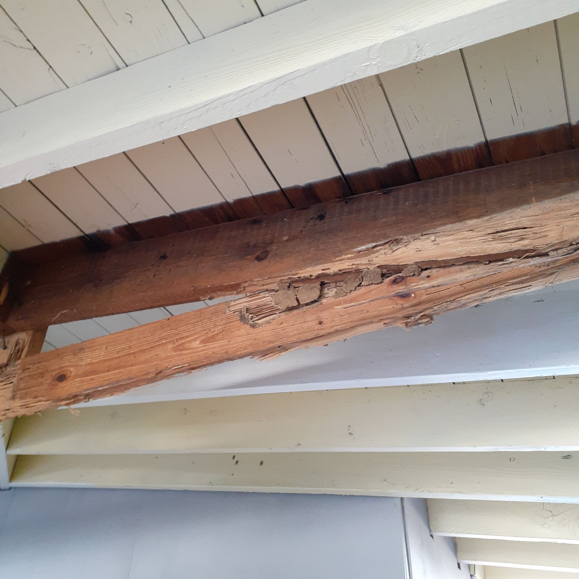A wooden beam is hanging from the ceiling of a building