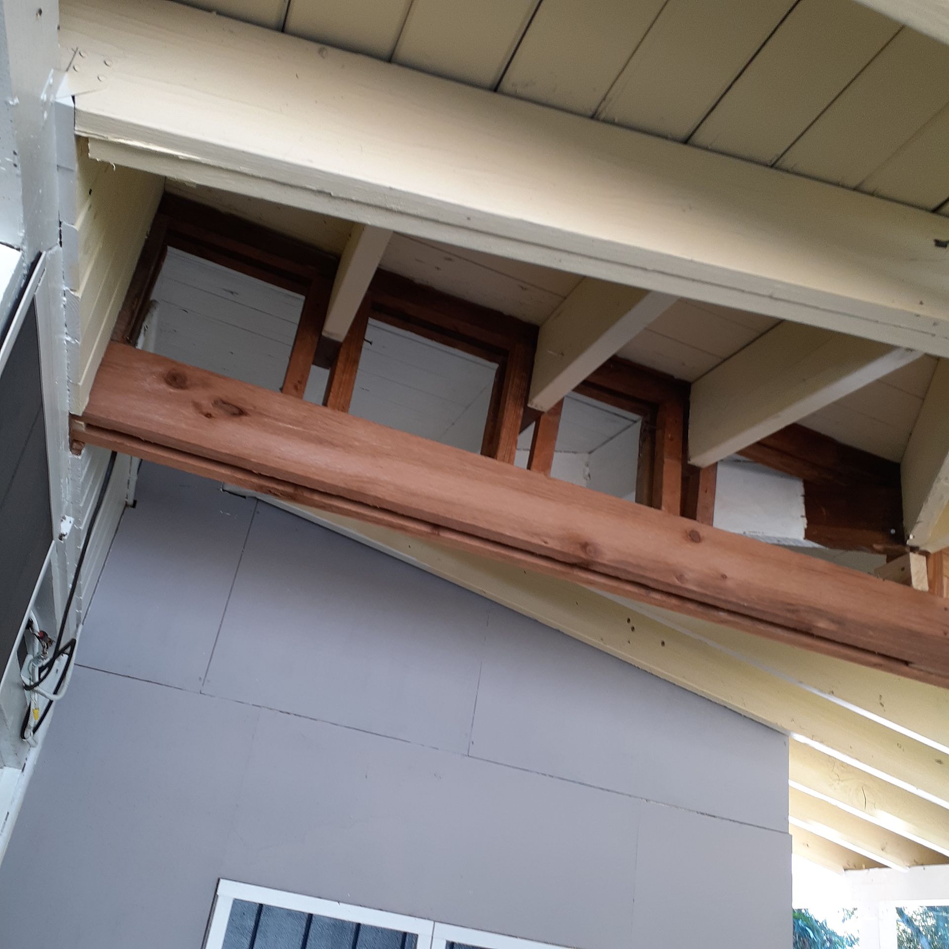 A wooden beam is hanging from the ceiling of a building