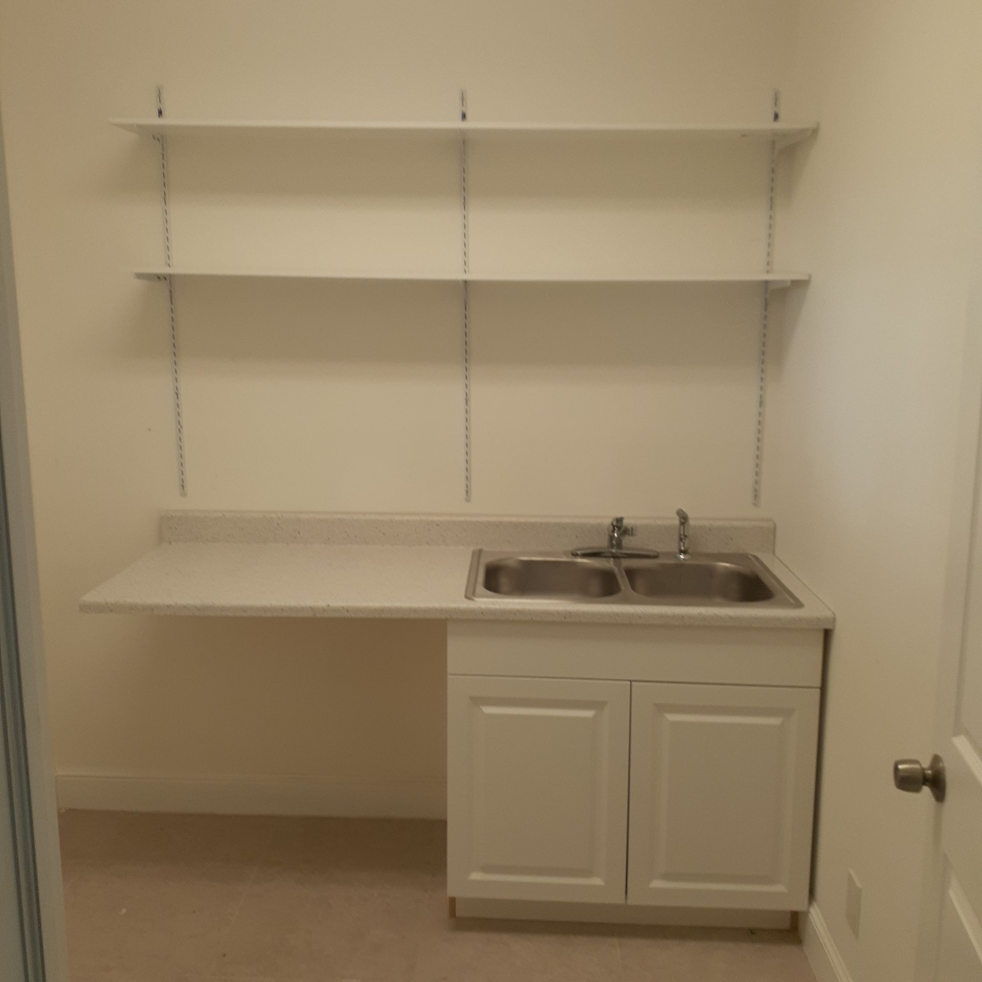 A kitchen with a sink and shelves above it