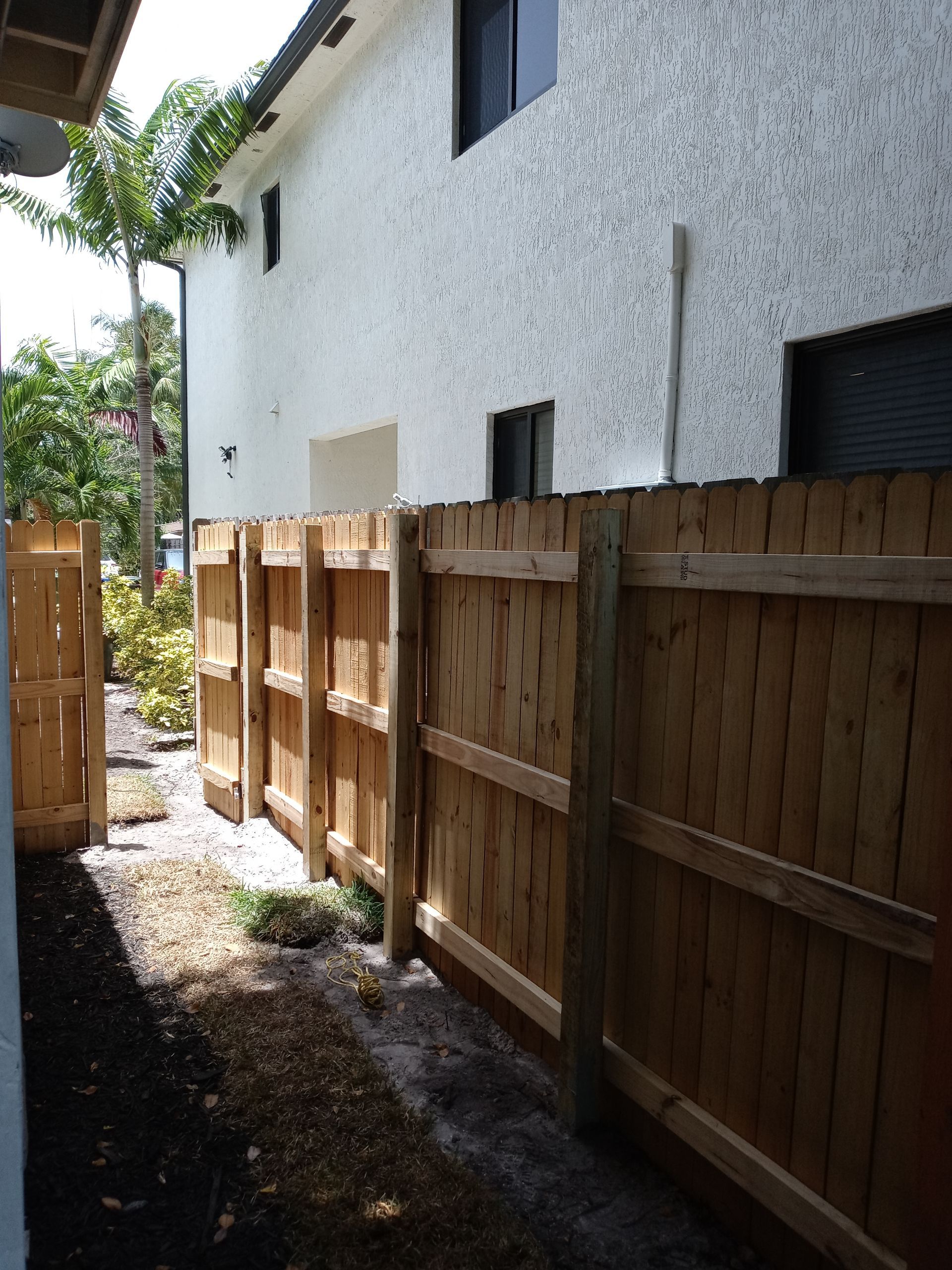 A white house with a wooden fence in front of it