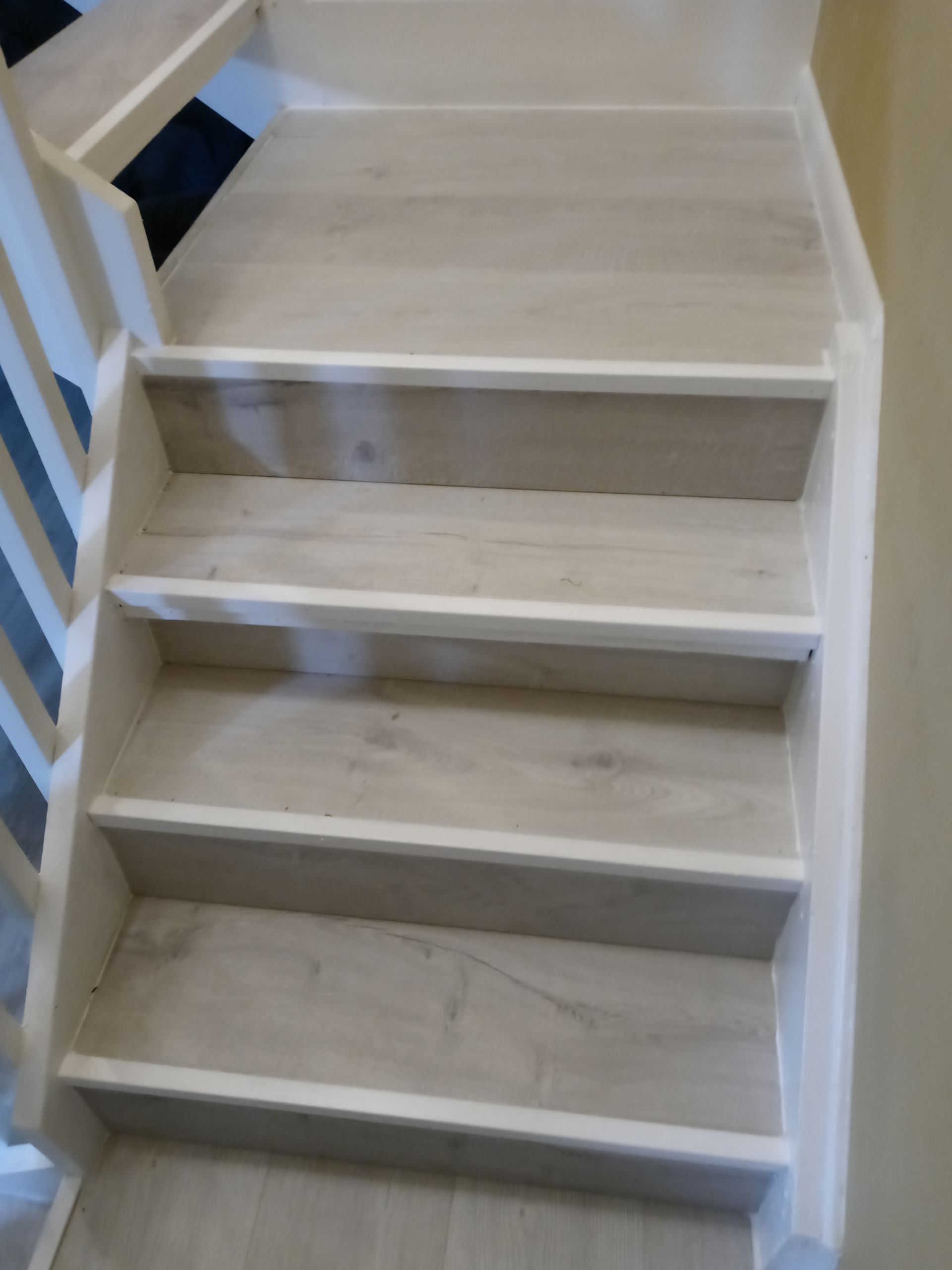 A set of white stairs with a white railing