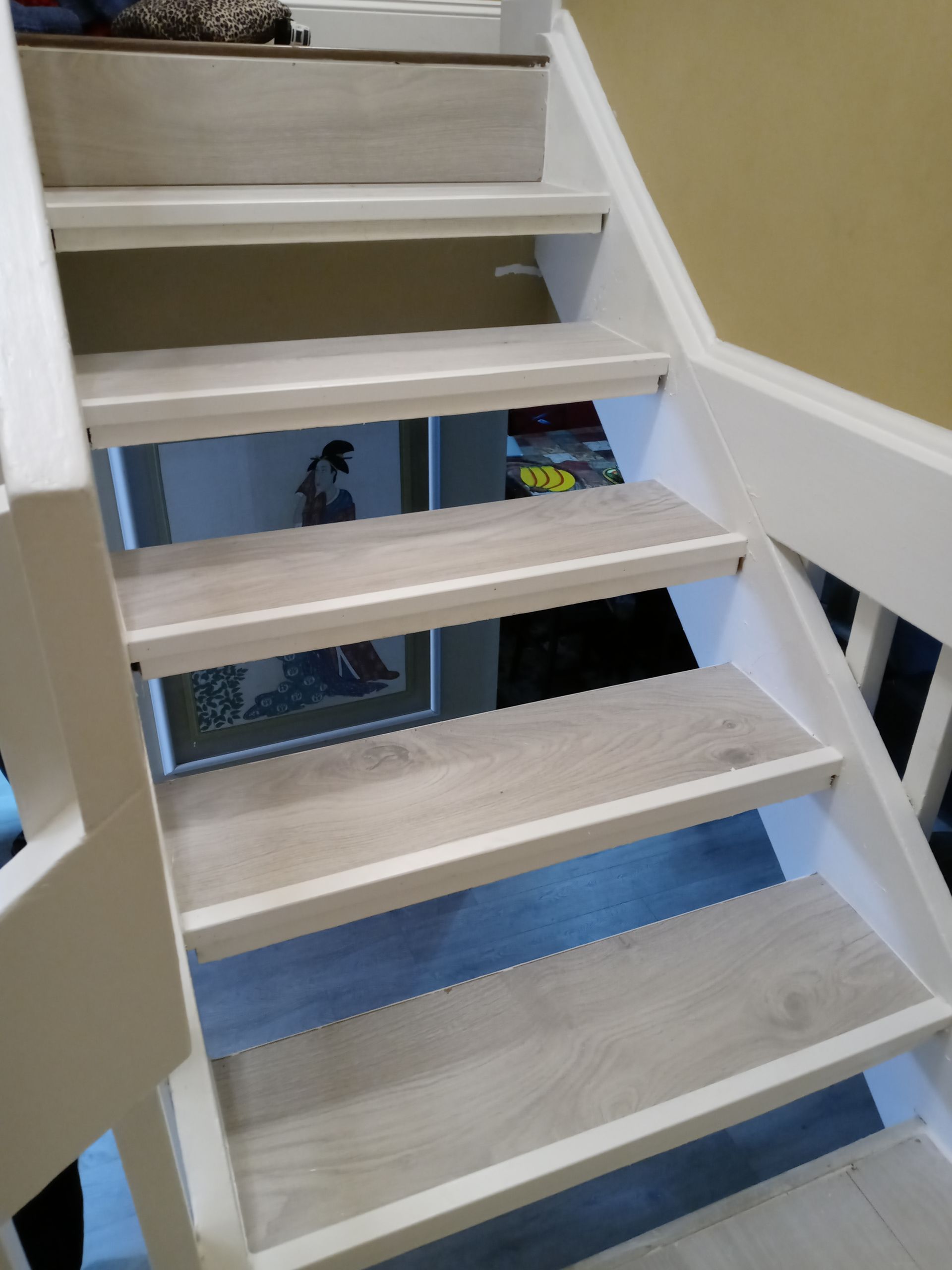 A white staircase with wooden steps and a white railing