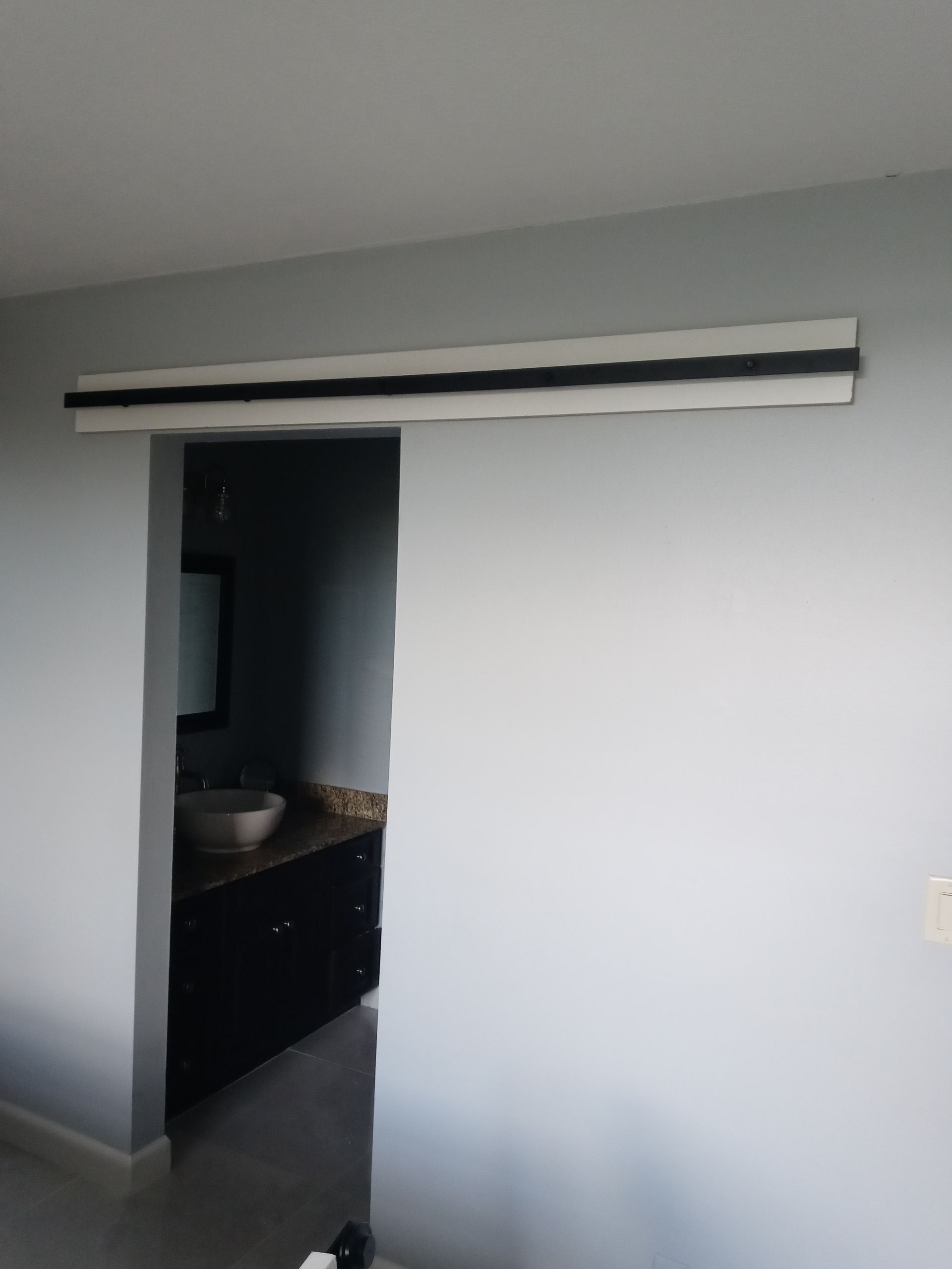 A bathroom with a sink and a sliding glass door