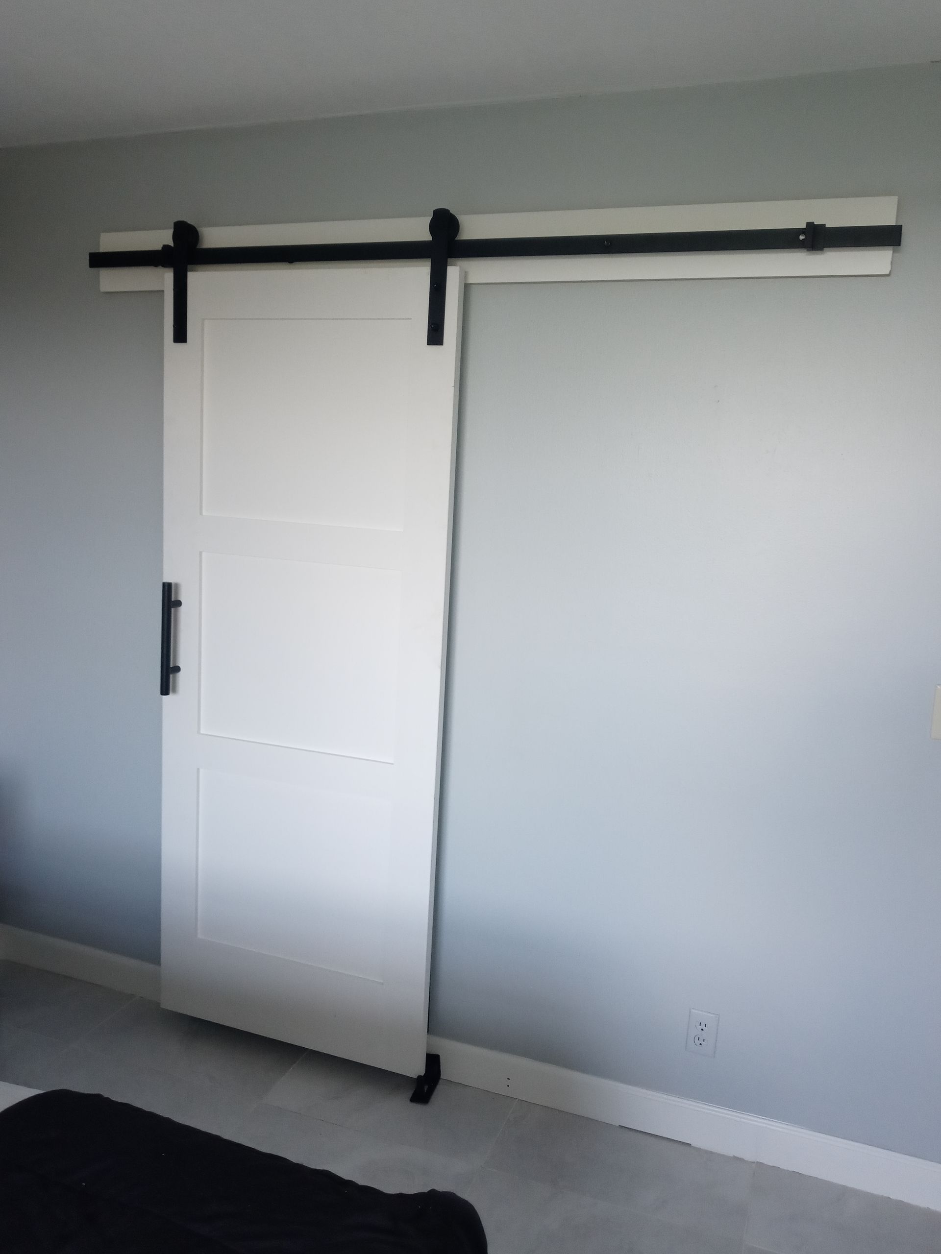A white sliding barn door is hanging on a wall in a living room.