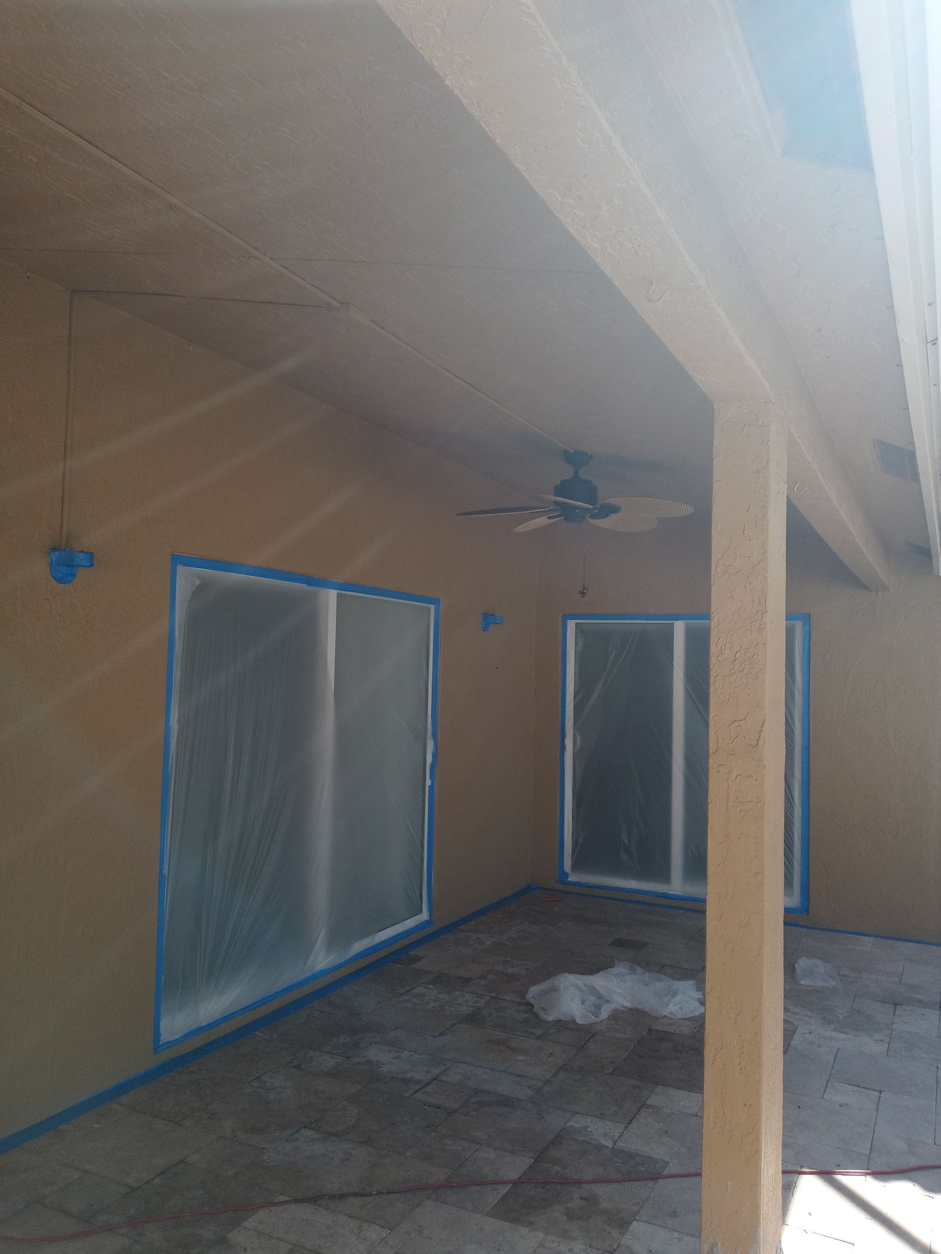 A house with sliding glass doors and a ceiling fan