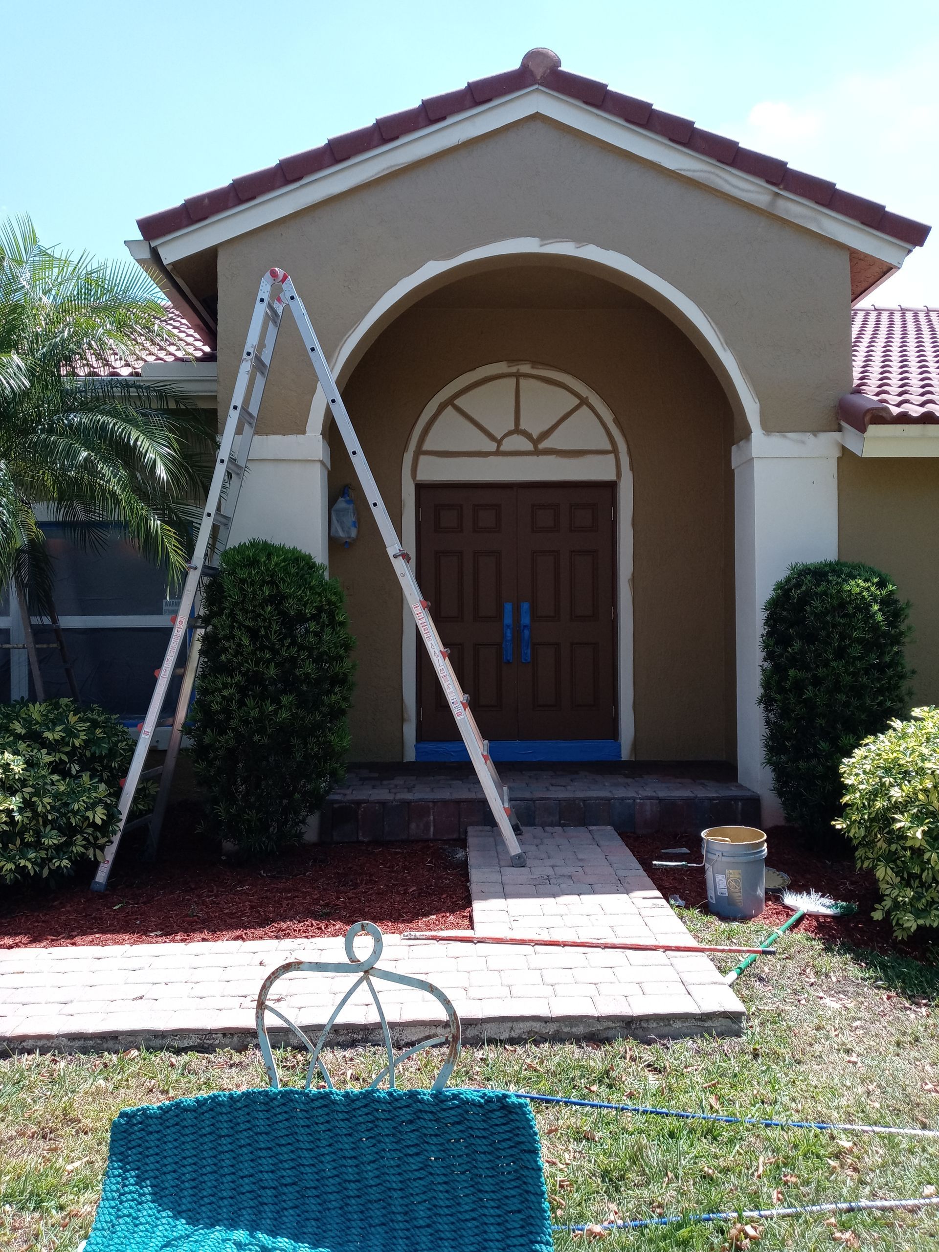 A house is being painted with a ladder in front of it