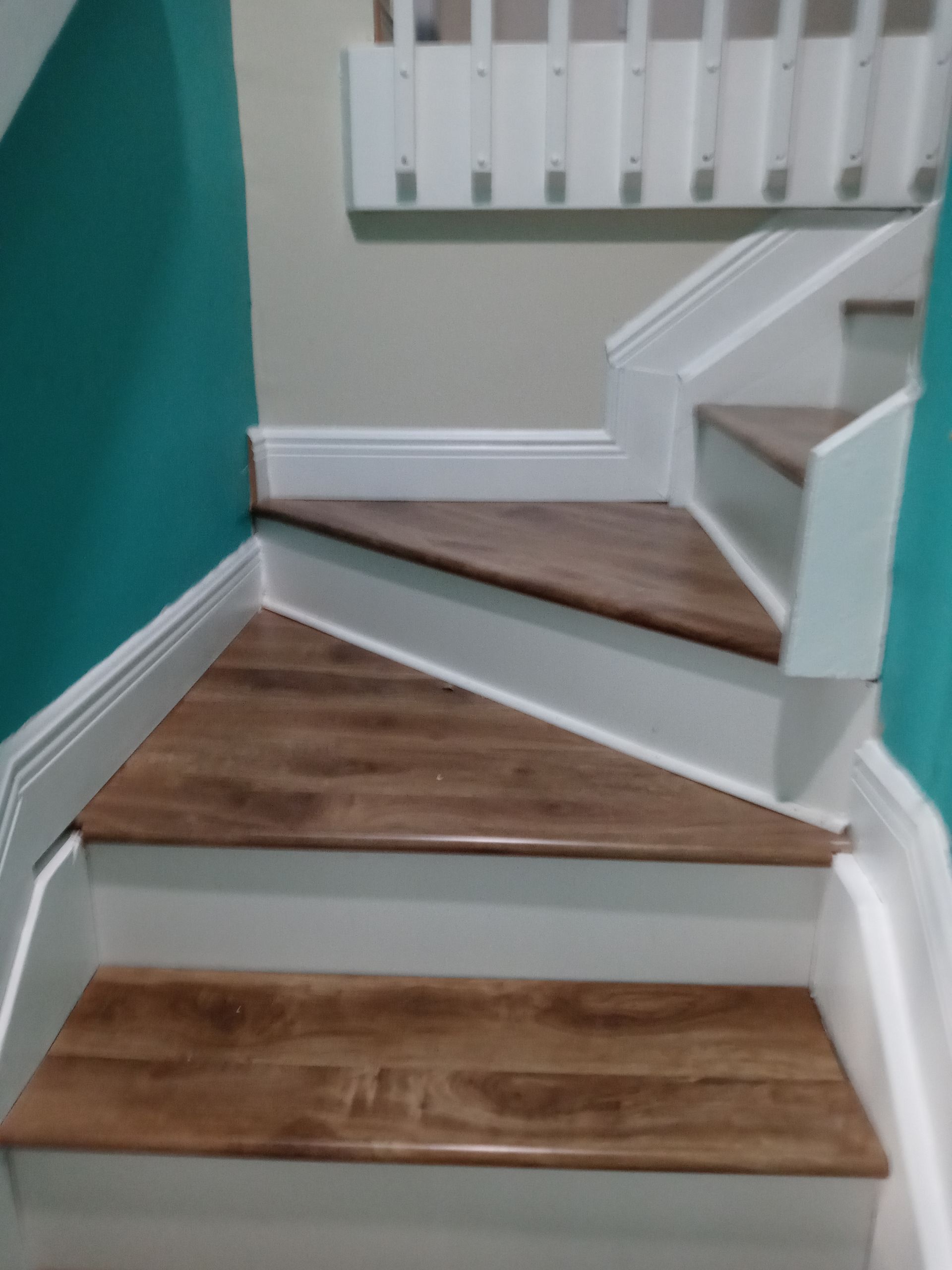 A set of stairs with wooden steps and white railing.