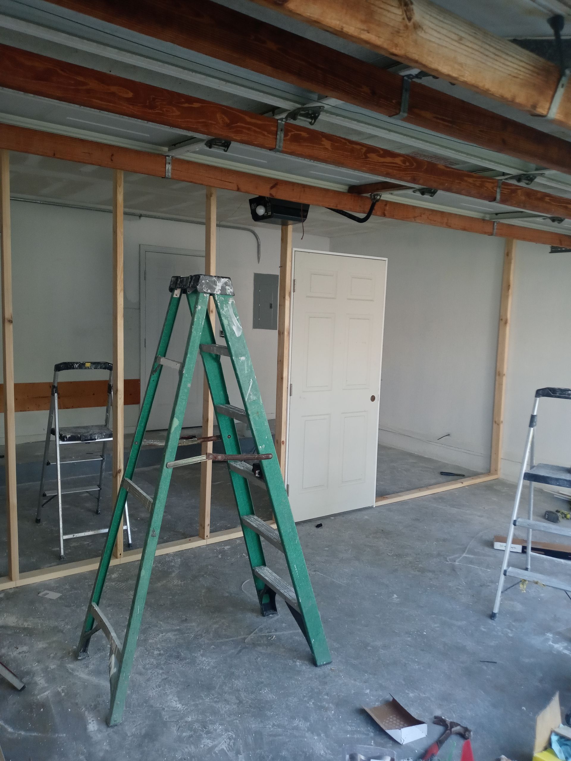 A green ladder is sitting in the middle of a room