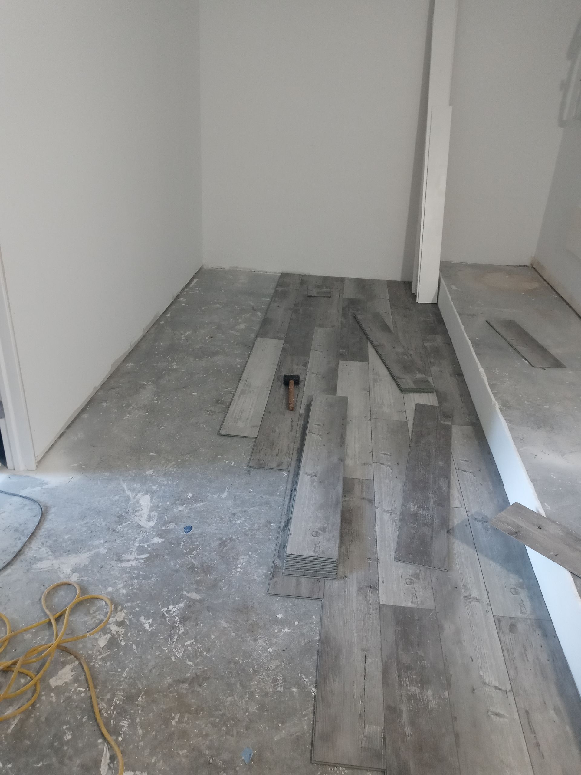 A room with a wooden floor and a white wall.
