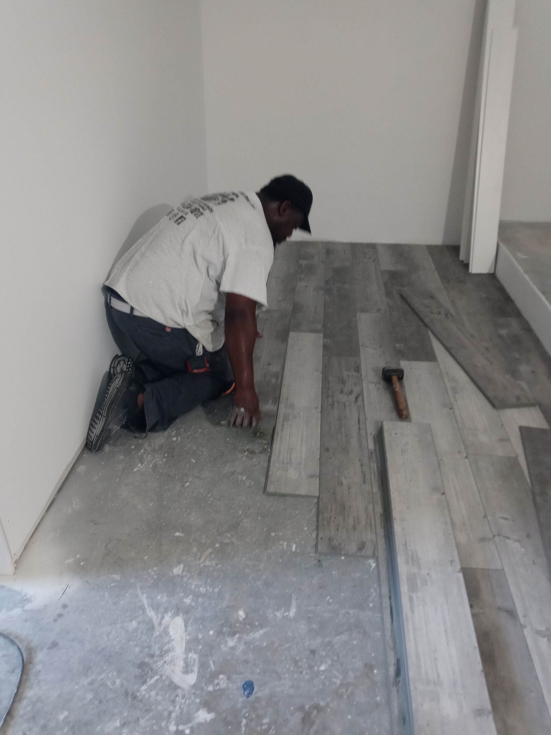 A man is kneeling on the floor in a room.