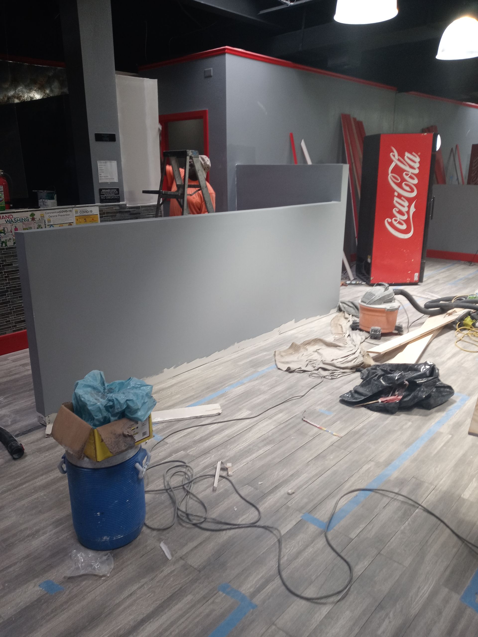 A coca cola vending machine is in the middle of a room
