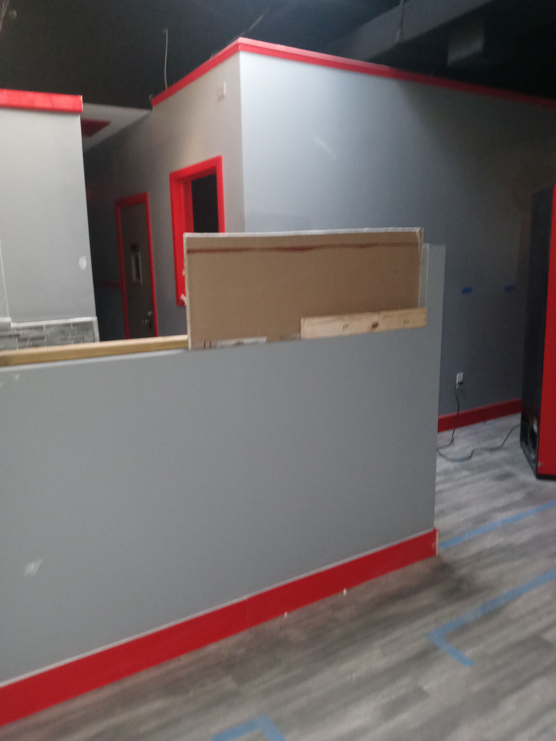 A room with a gray wall and red trim