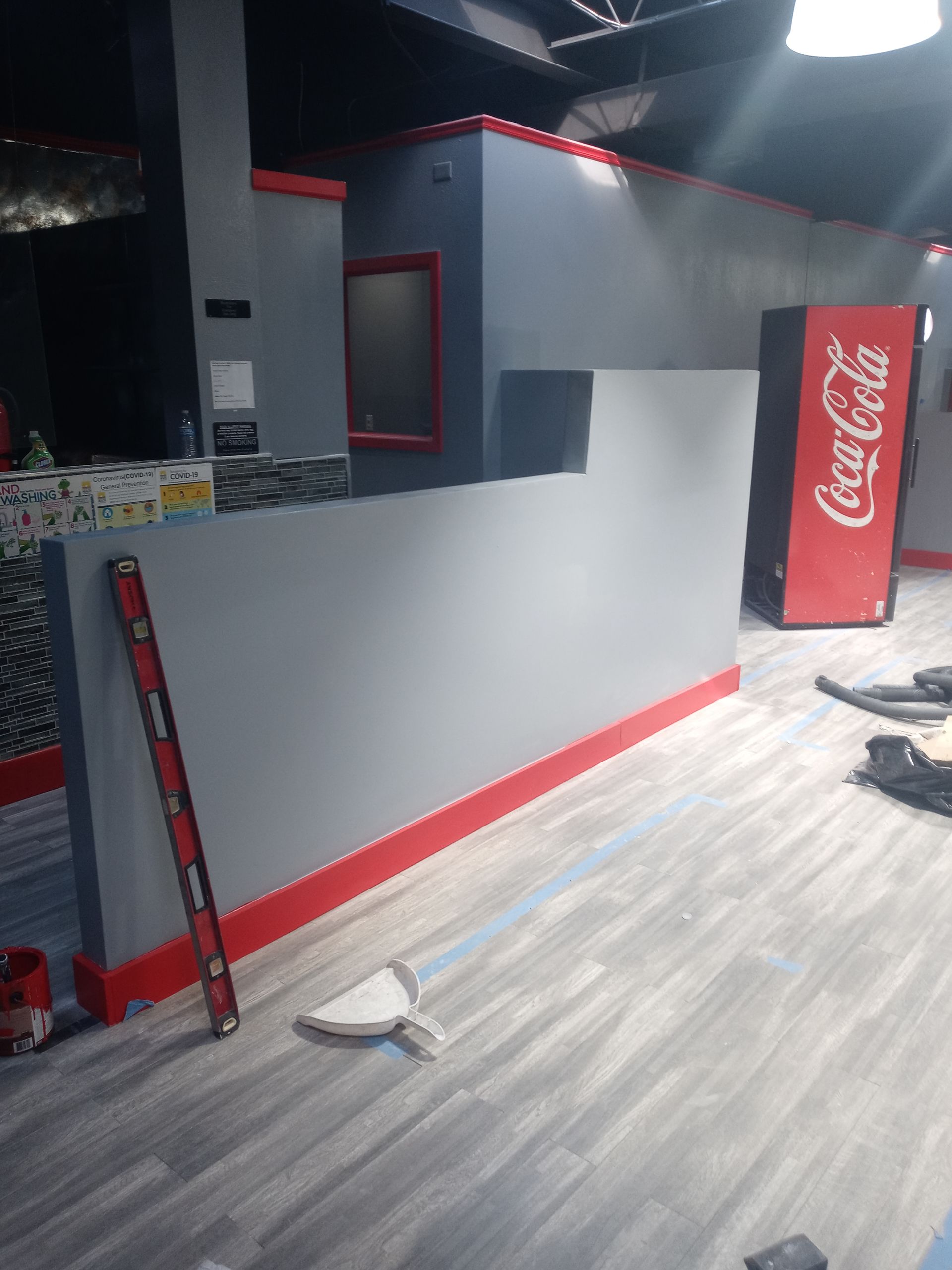 A coca cola vending machine is in the middle of a room