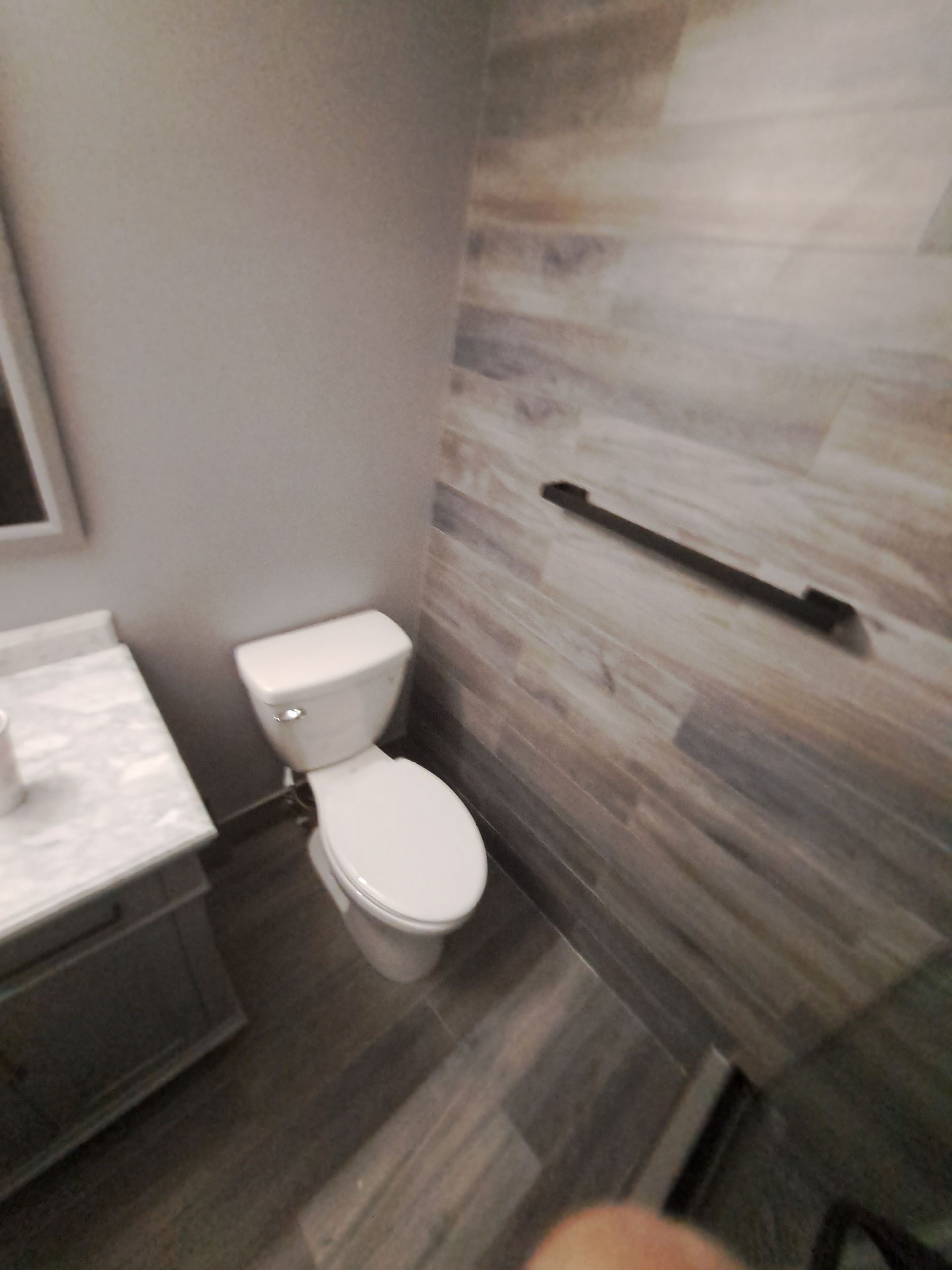A bathroom with a toilet , sink and mirror.