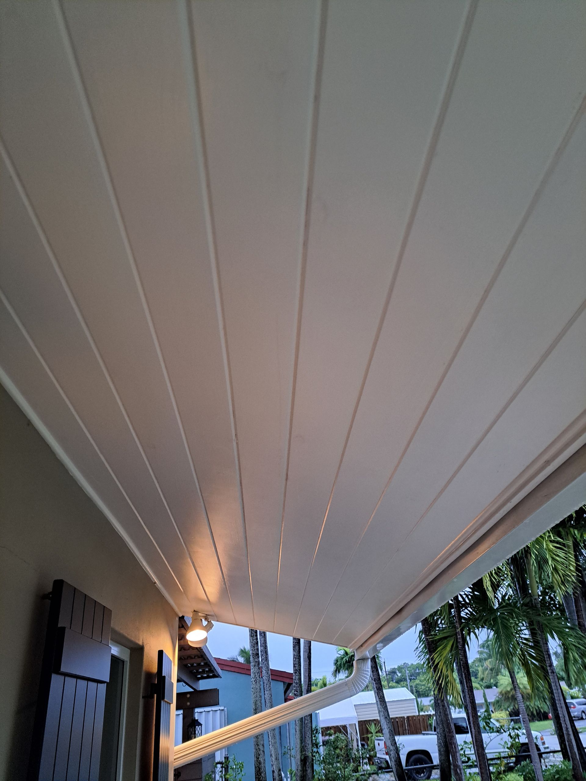 A white awning is hanging from the ceiling of a house.