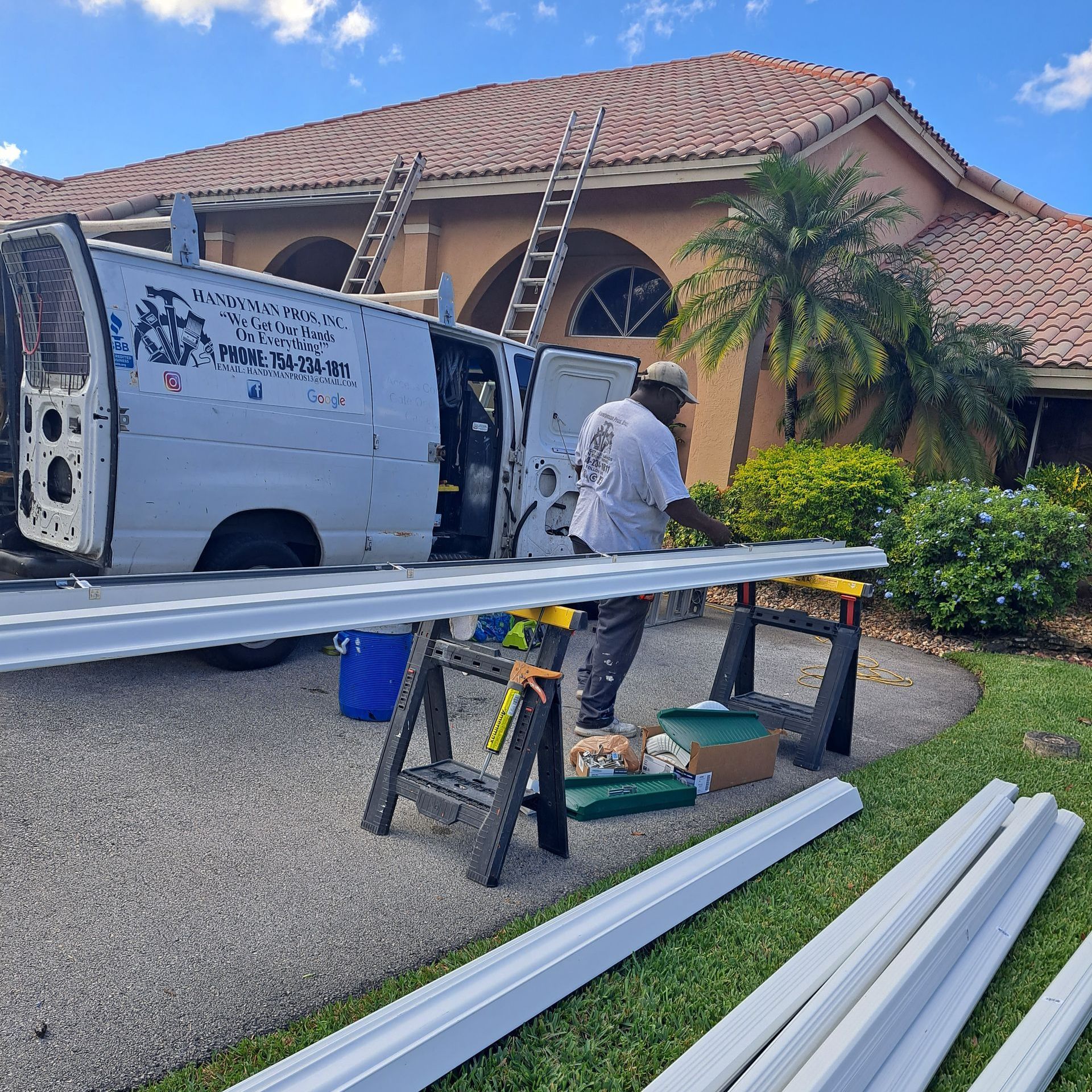 A man is working on a roof with a van in the background.
