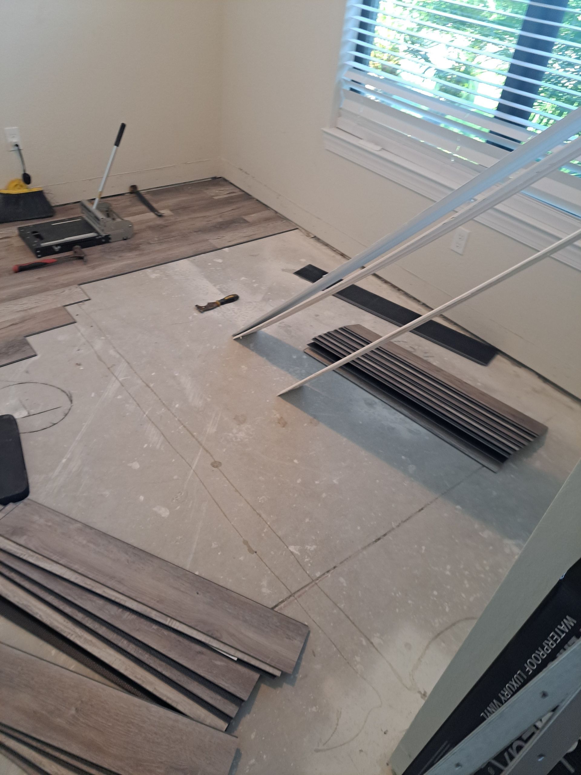 A room with a lot of wooden flooring and a window.