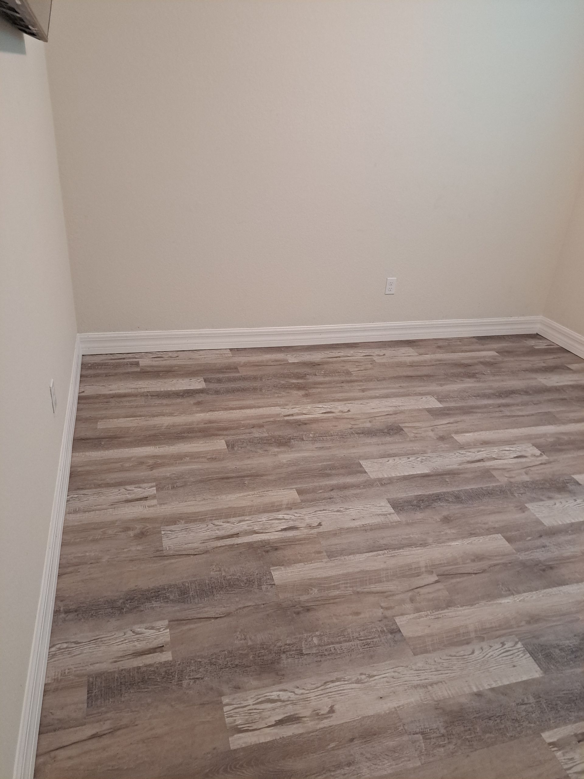 A room with a wooden floor and white walls.