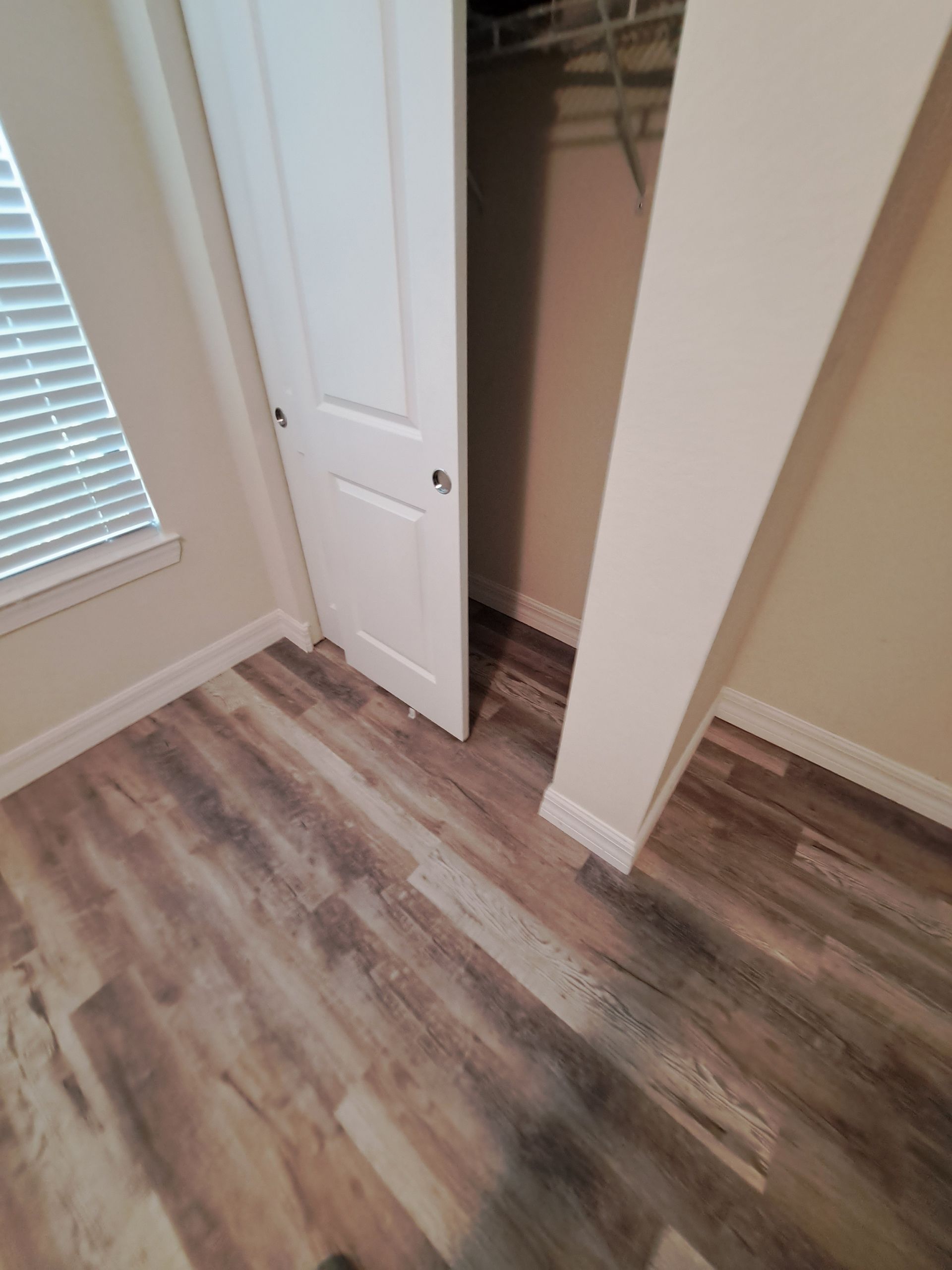A bedroom with hardwood floors and a closet.