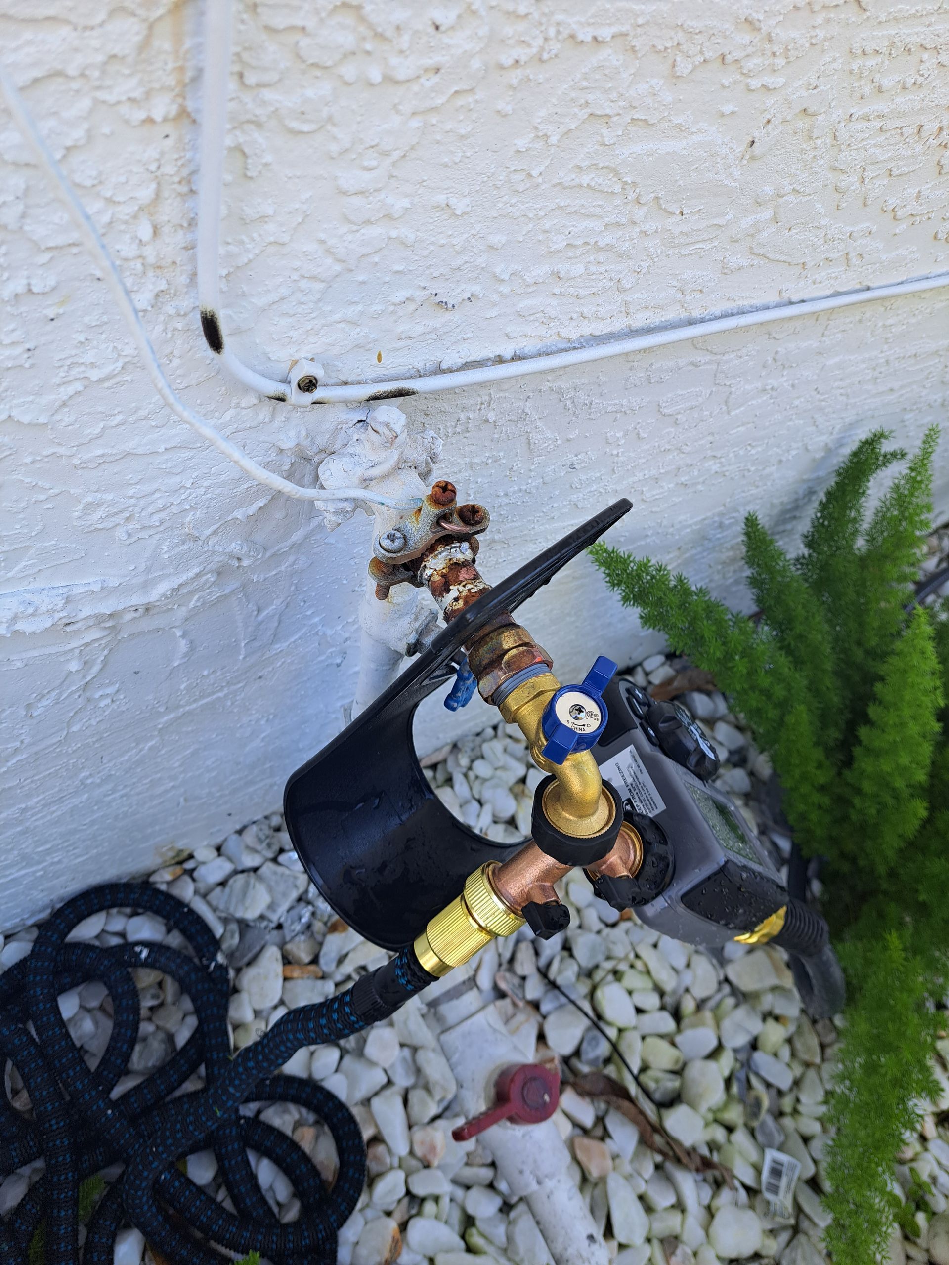 A hose is attached to a faucet on the side of a building.