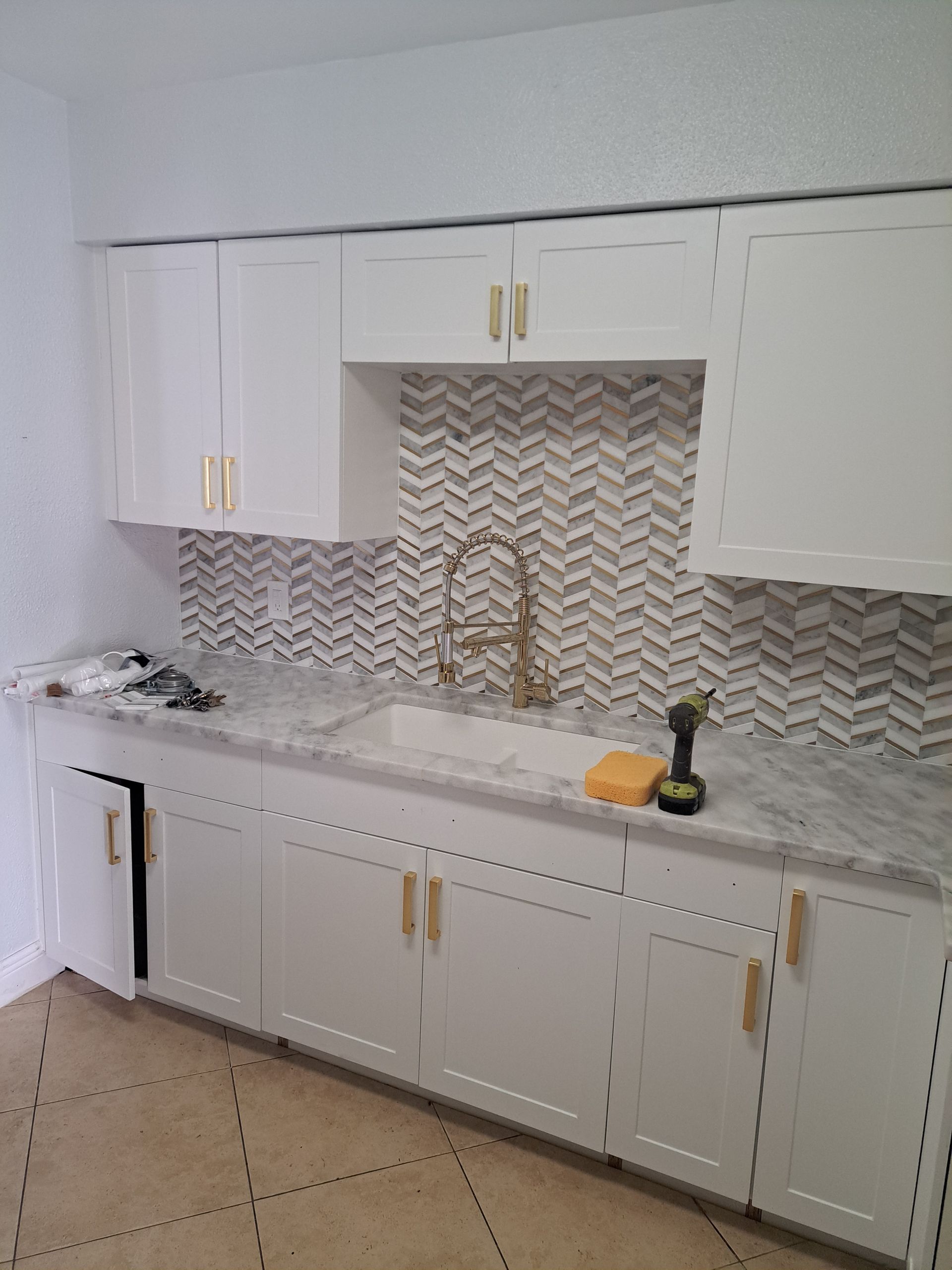 A kitchen with white cabinets and a sink