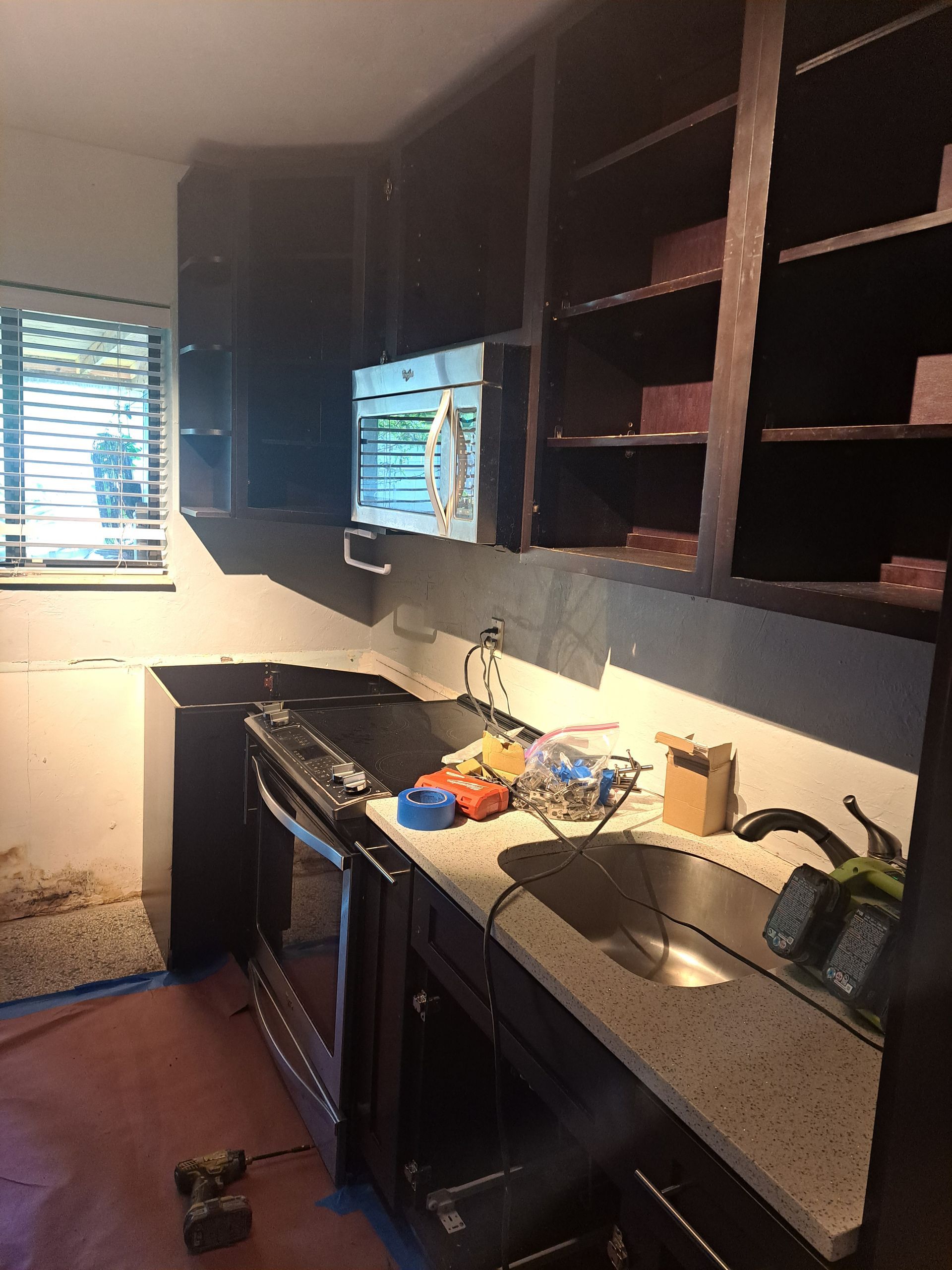 A kitchen with a stove , sink , and microwave.