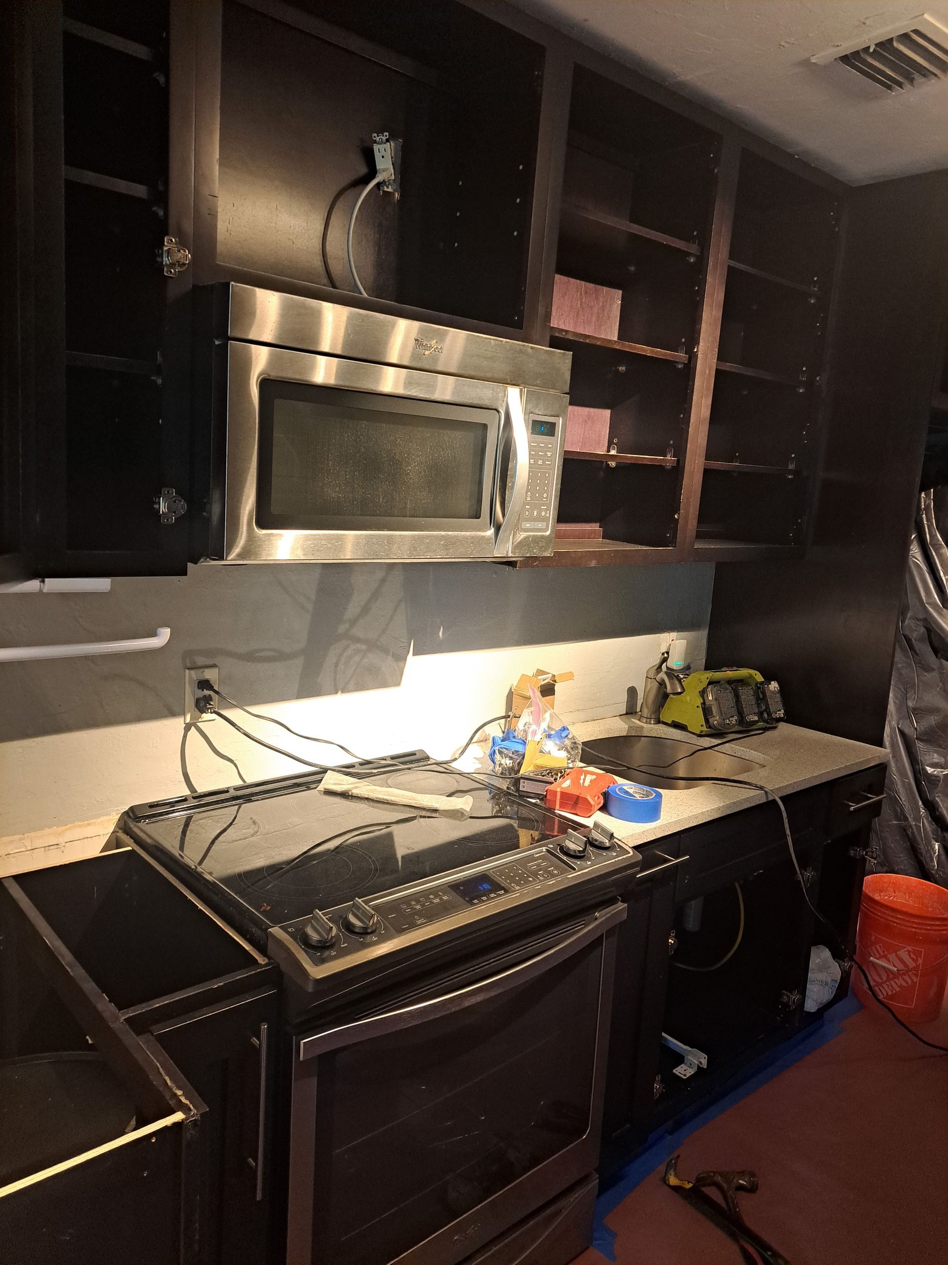 A kitchen with stainless steel appliances and black cabinets
