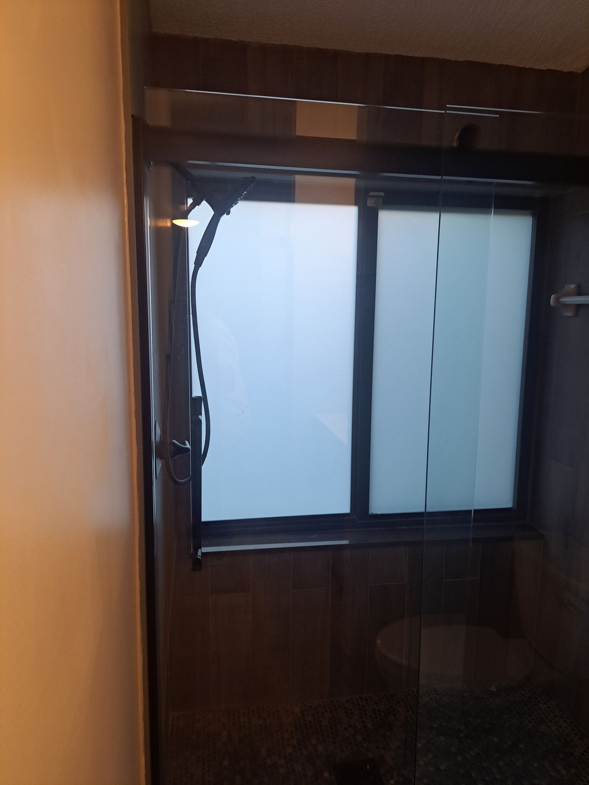 A bathroom with a window and a shower head