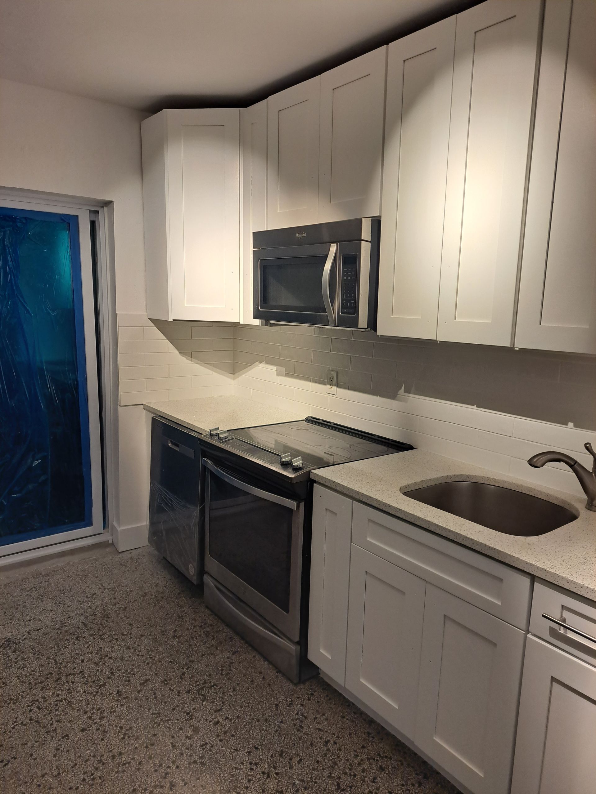 A kitchen with white cabinets and stainless steel appliances
