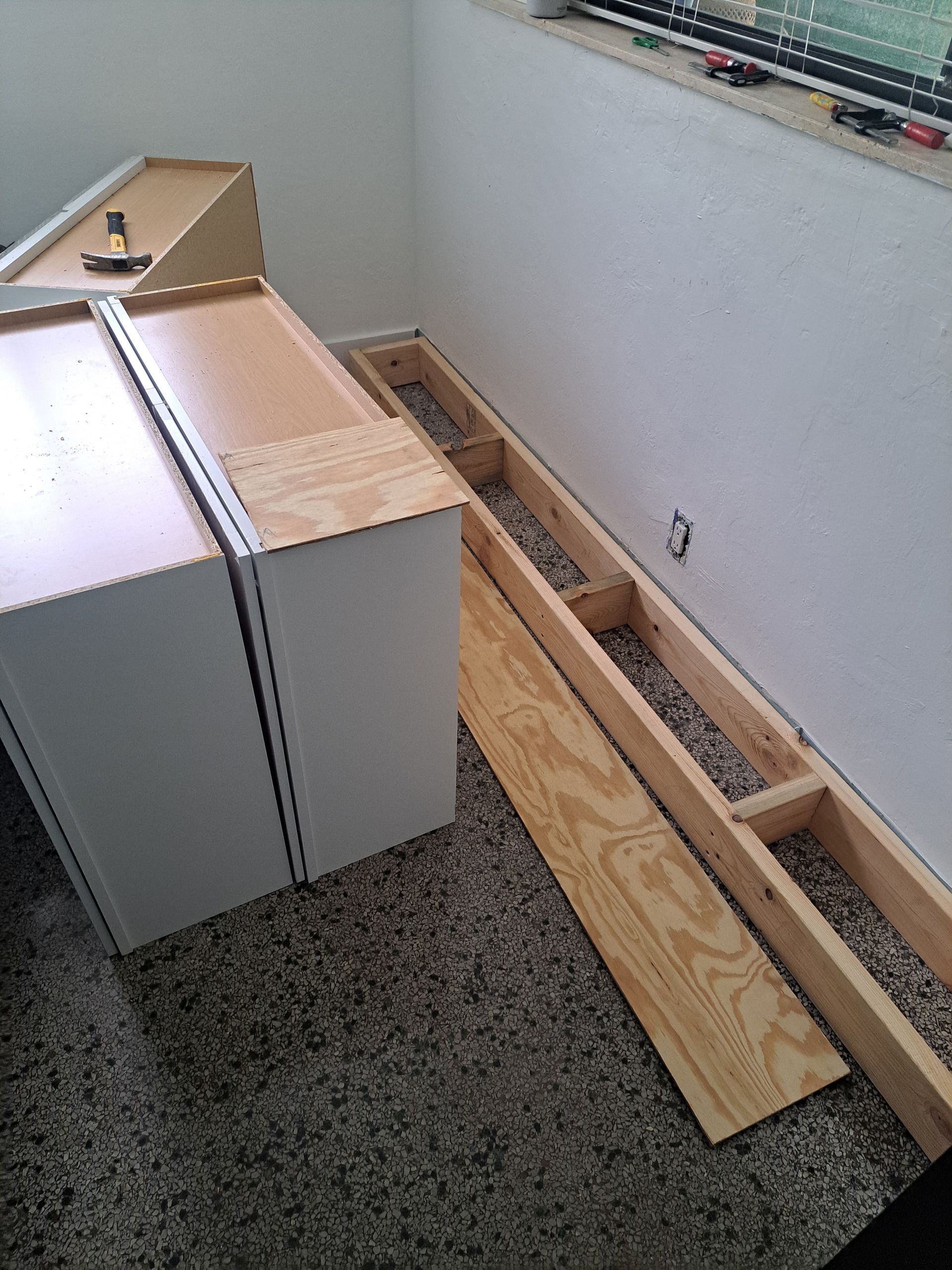 A piece of wood is laying on the floor next to a dresser.