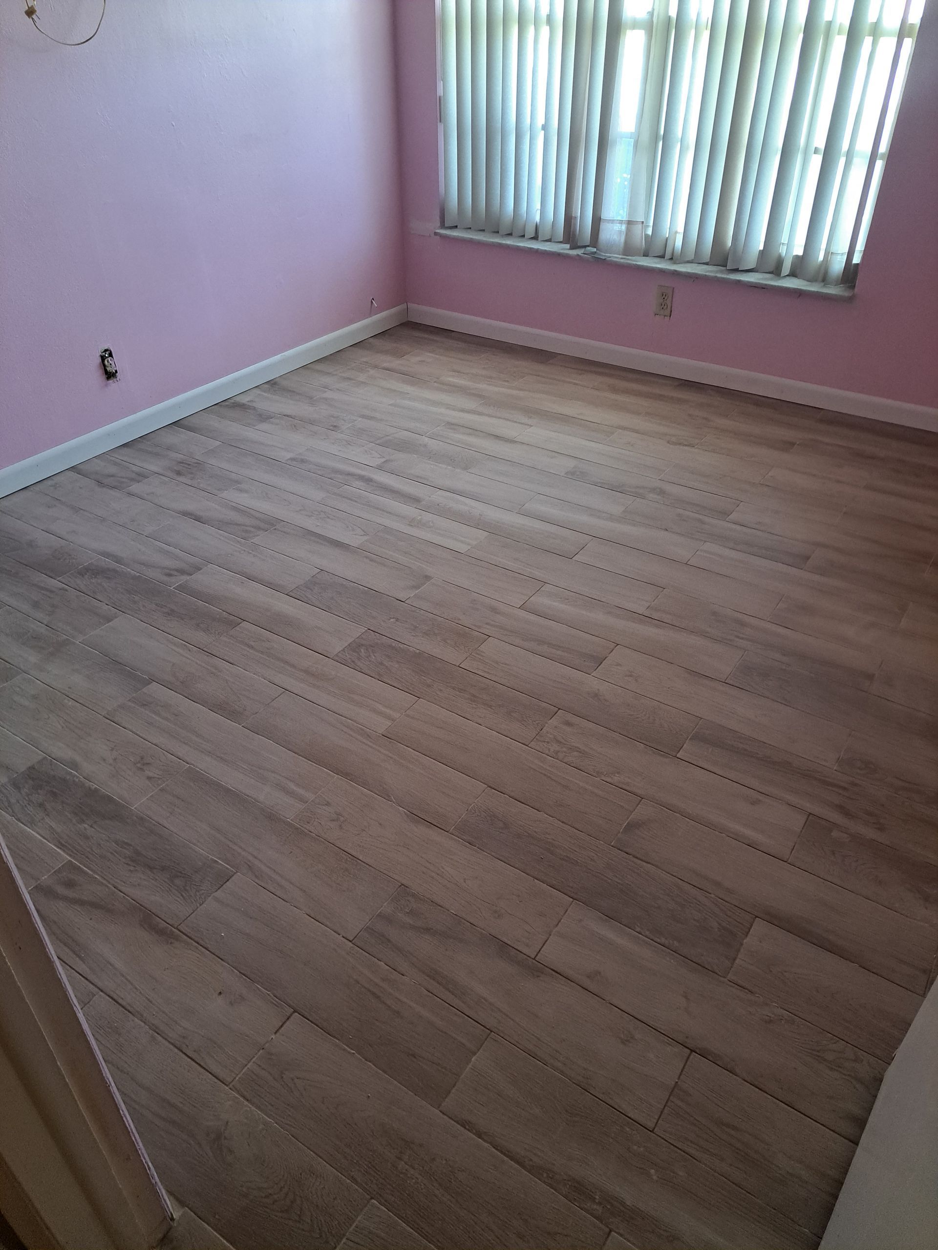 A room with a wooden floor and a window.
