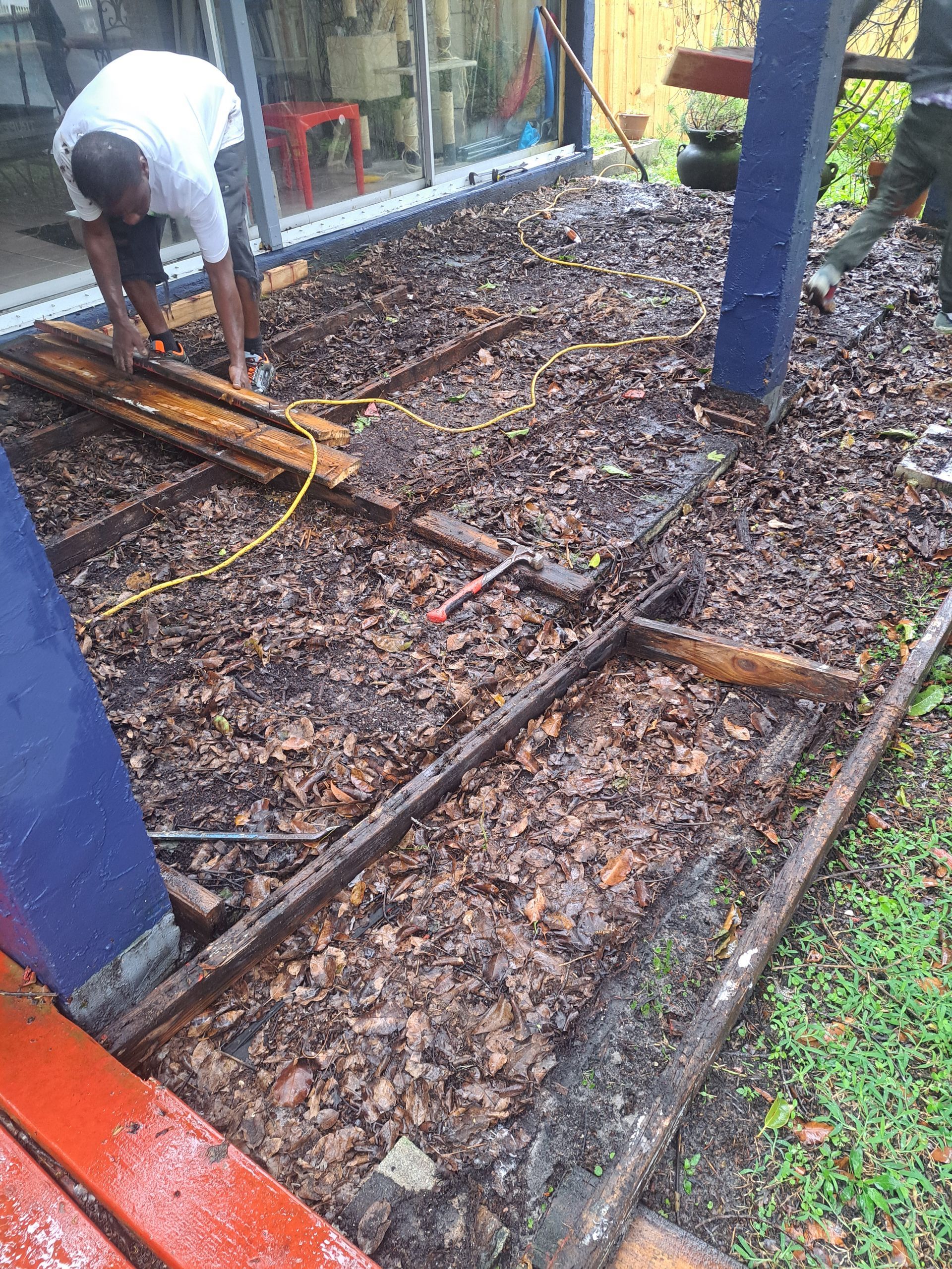 A man is working on a wooden deck.