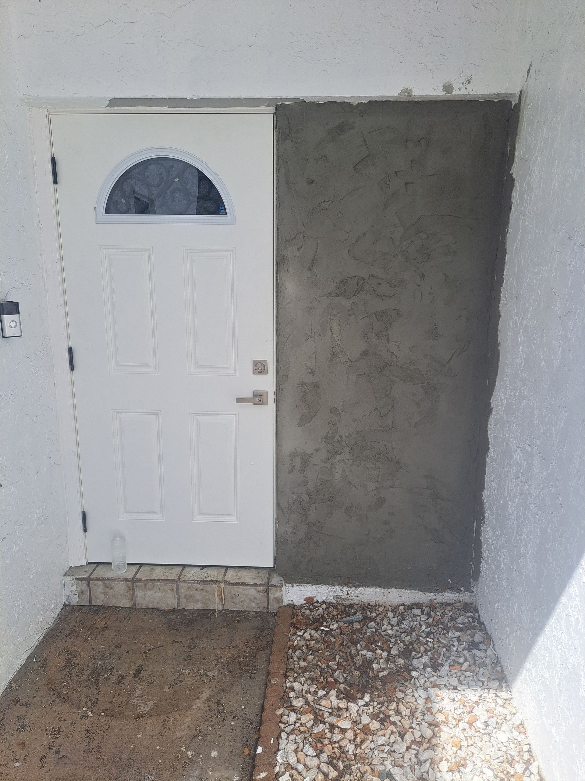 A white door is sitting next to a concrete wall.