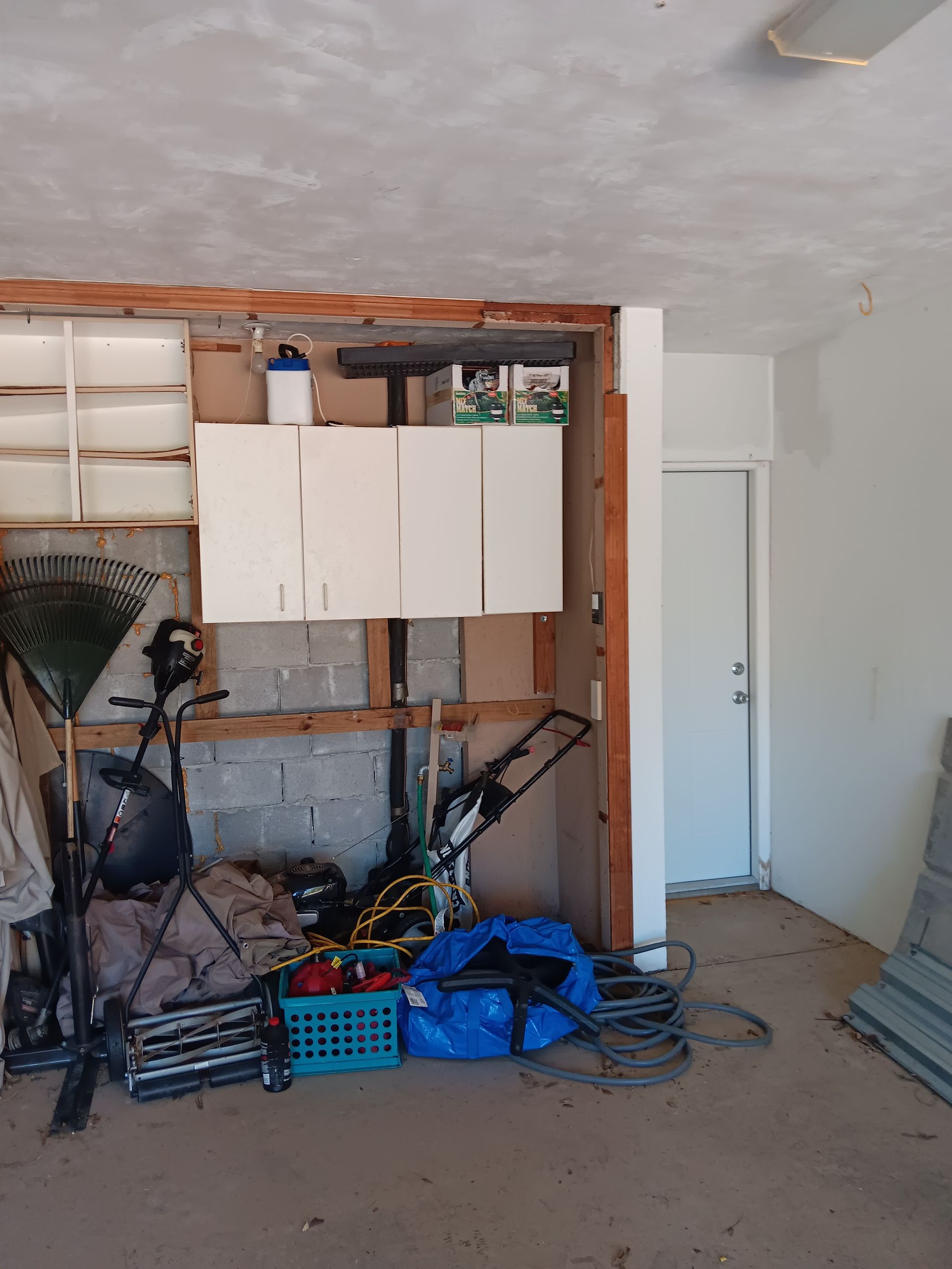 A garage filled with lots of items including a blue bag